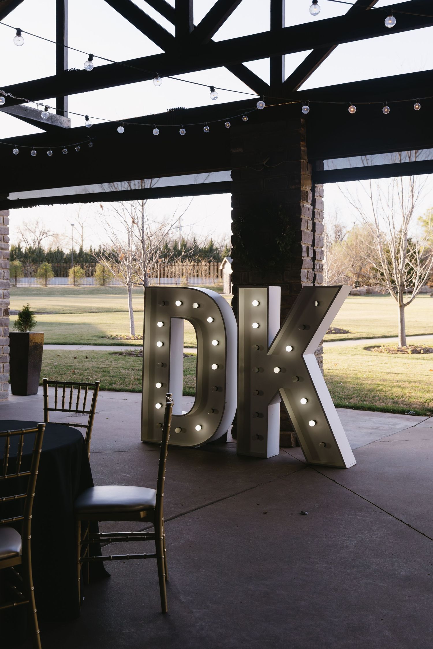 Modern wedding venue with illuminated marquee letters and industrial beams.