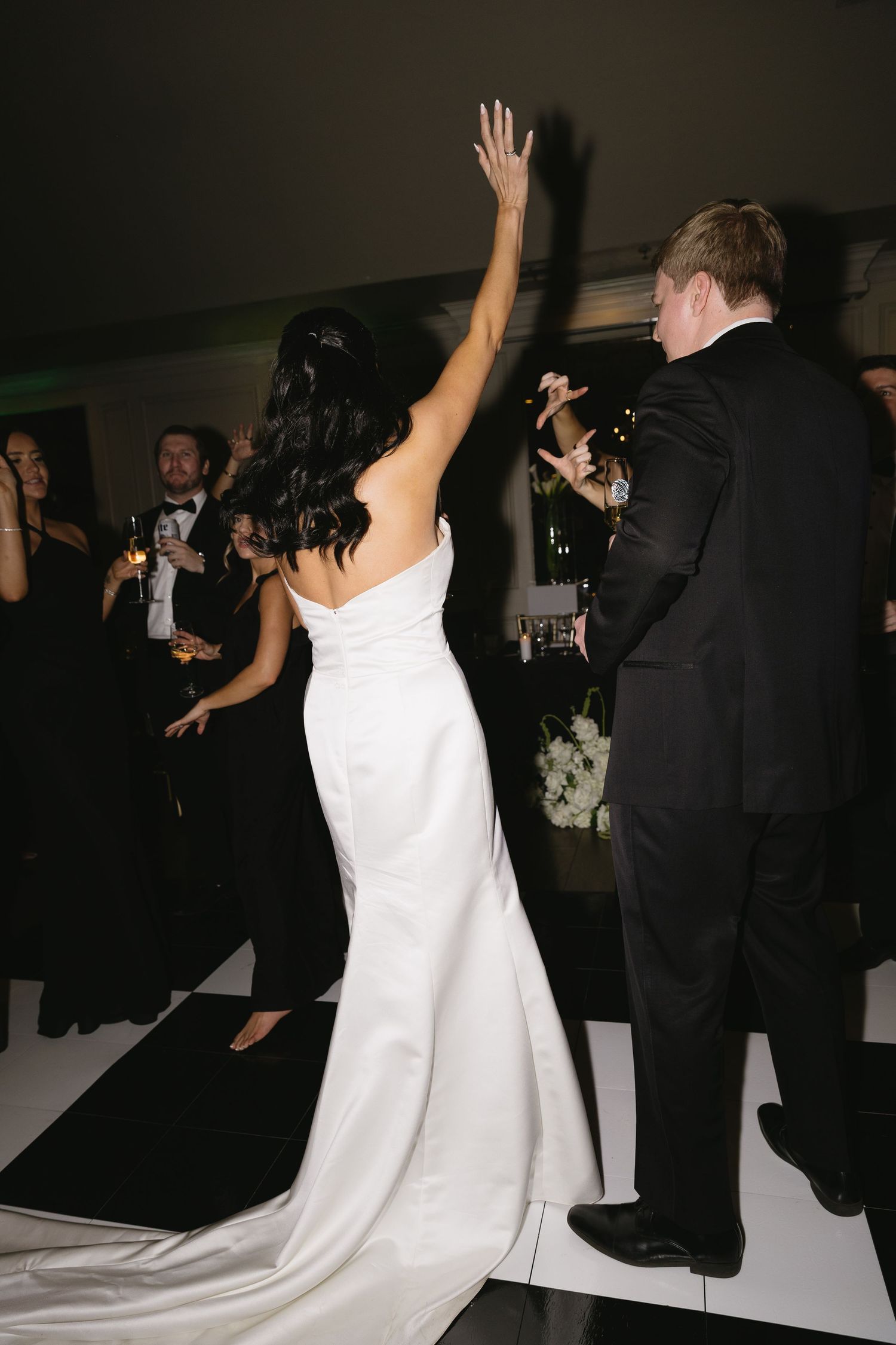 Wedding reception dance floor with guests in formal attire dancing and celebrating.
