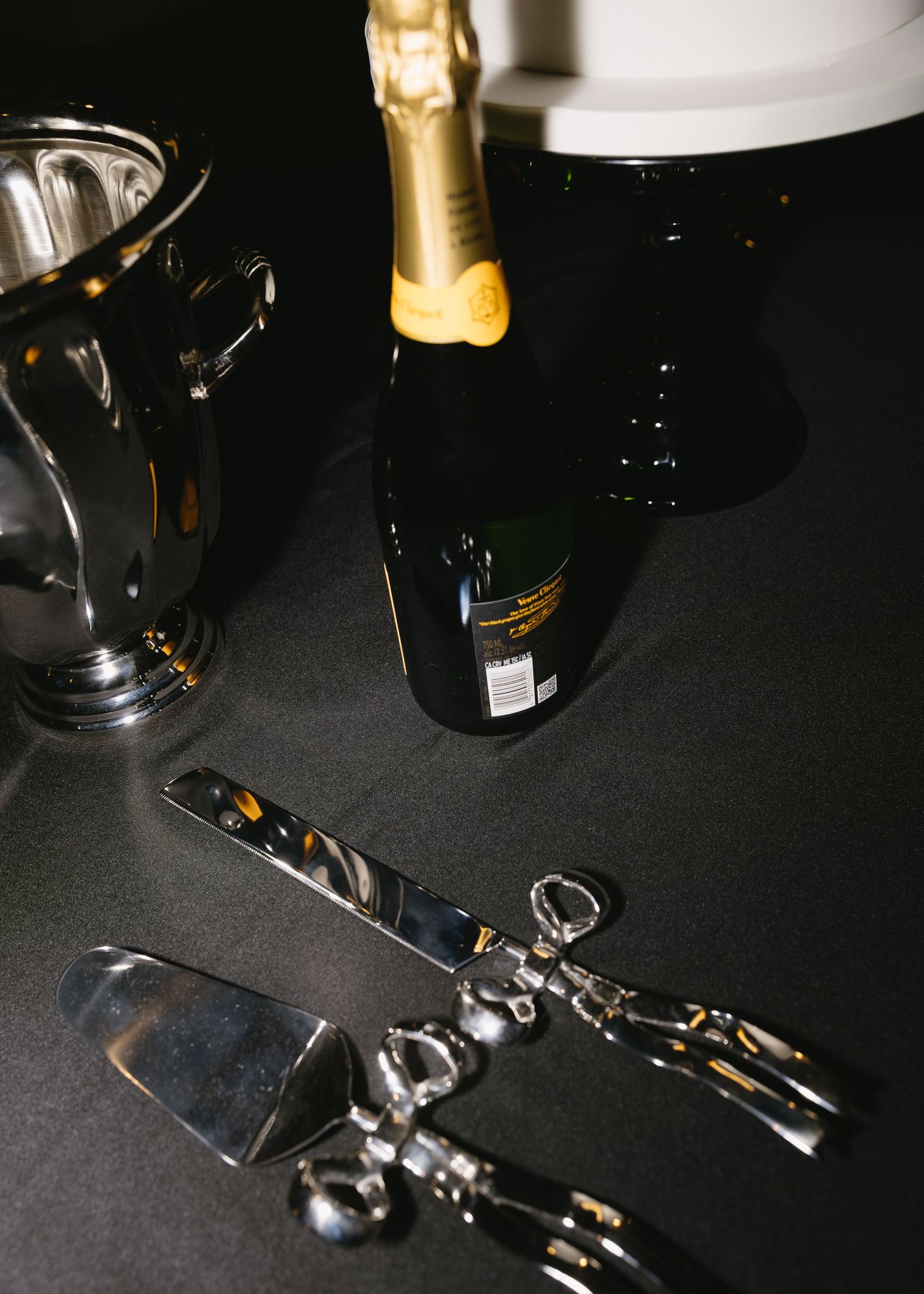 Wine glasses and champagne bottles arranged on a dark table surface.