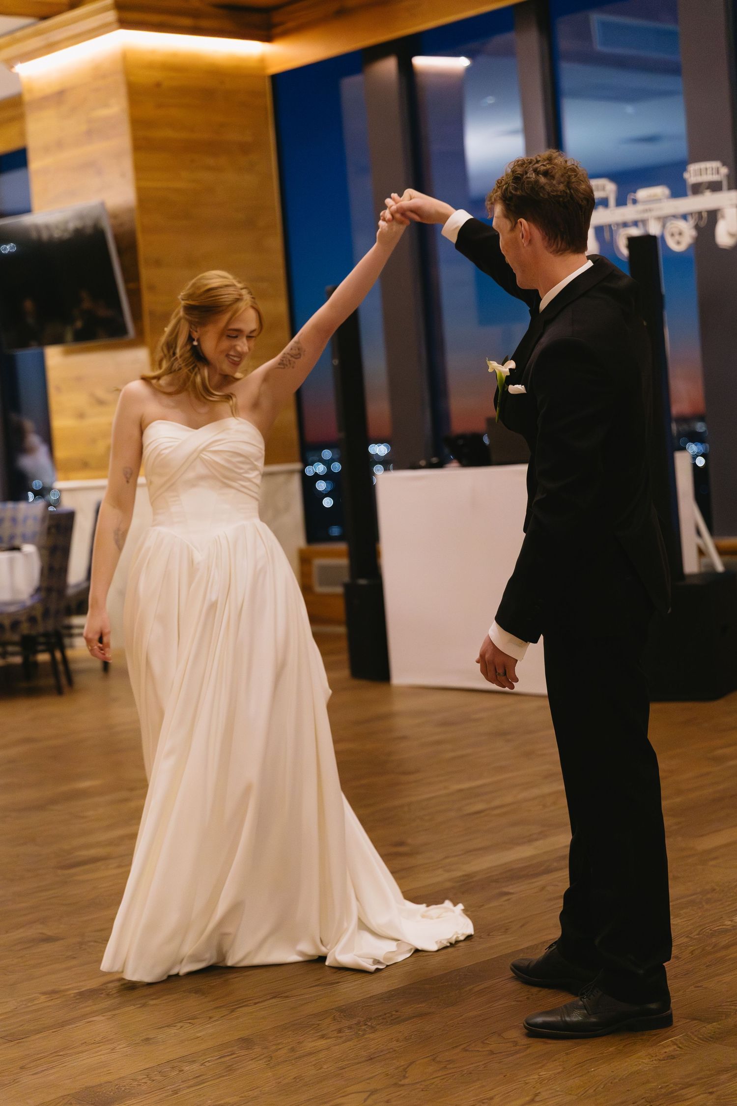 Couple dancing on wooden floor during their wedding reception.