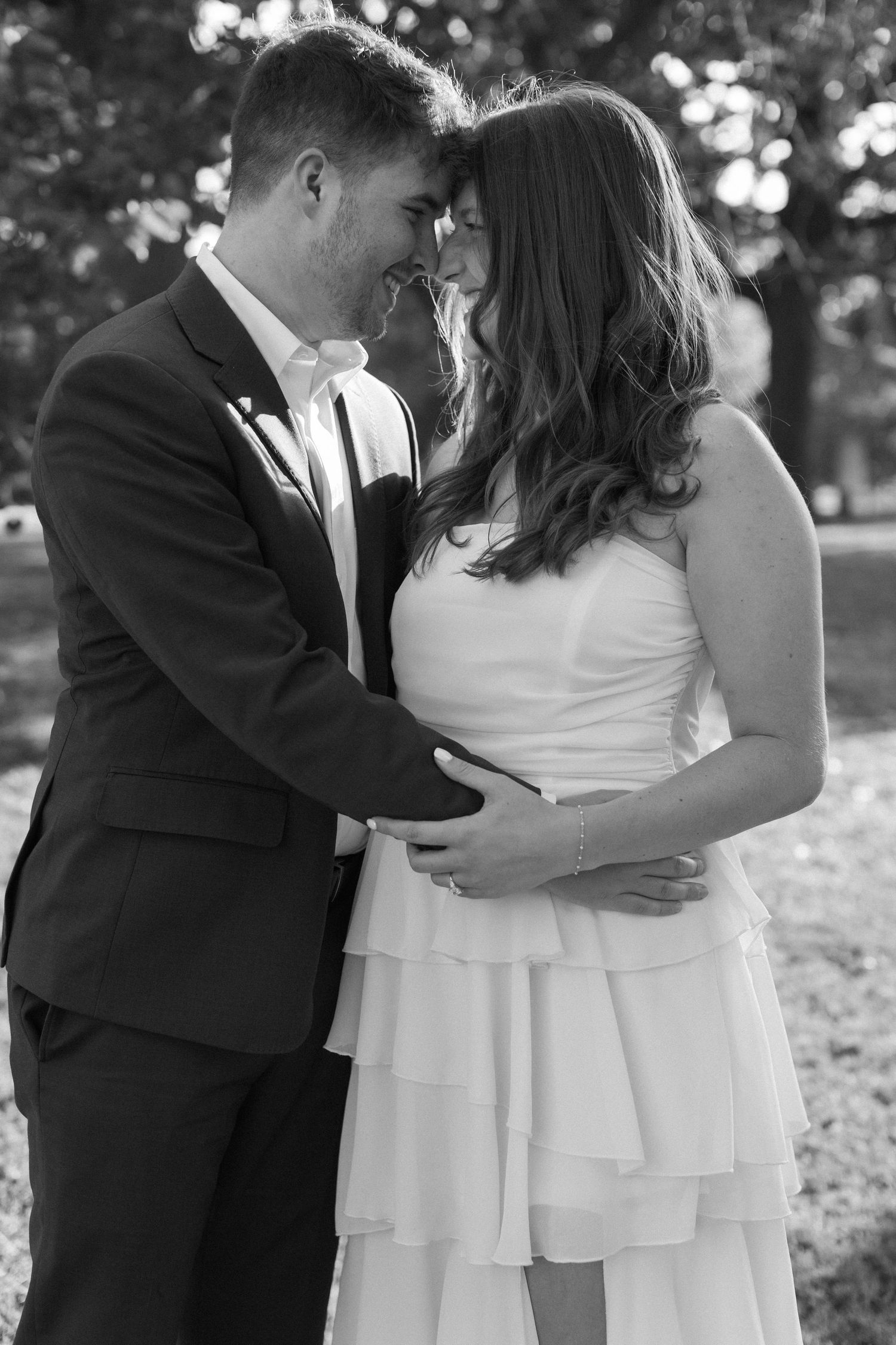 A romantic black and white photo sequence showing a couple embracing during a wedding photoshoot outdoors.