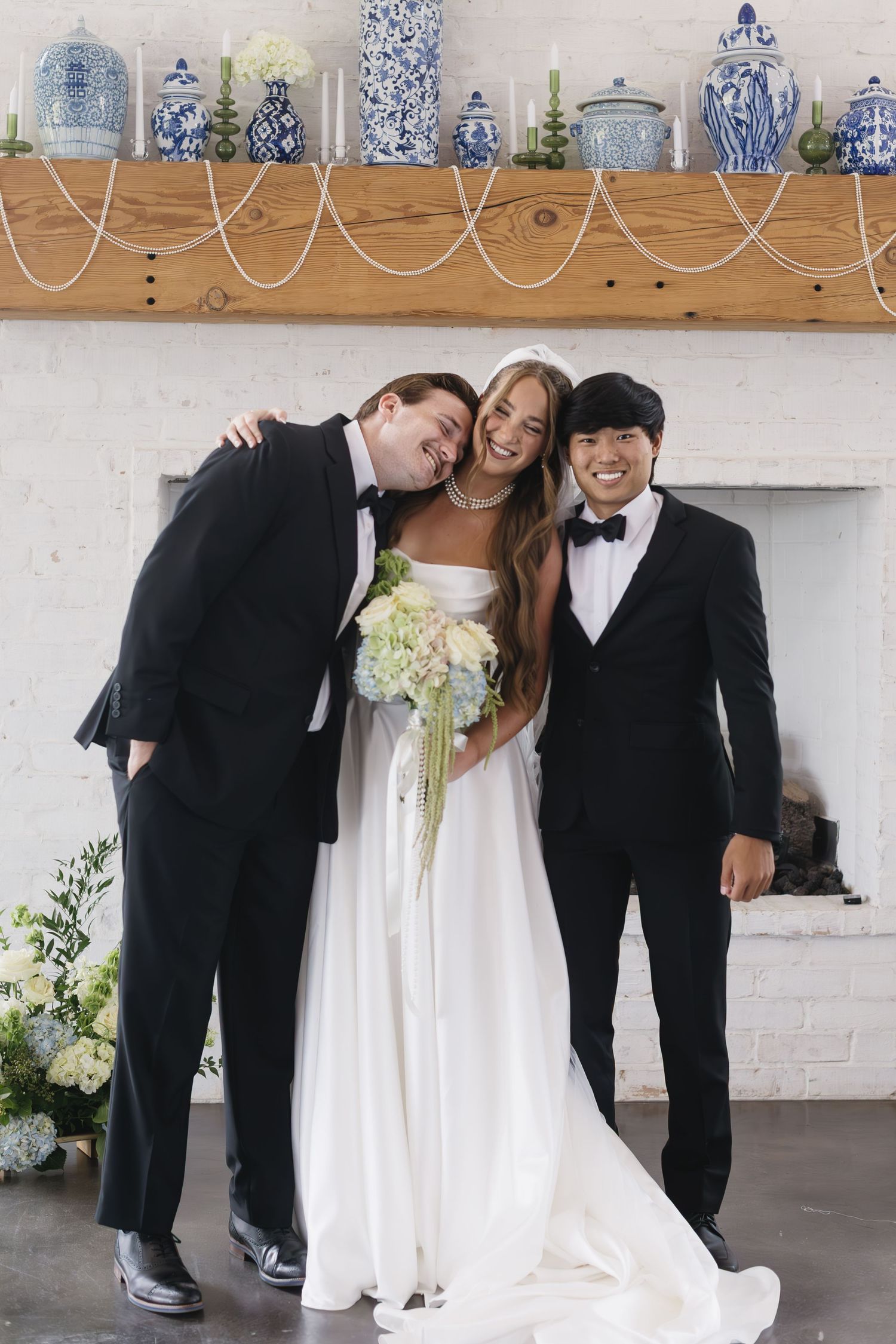 Wedding party poses under decorative blue and white pottery display shelf.
