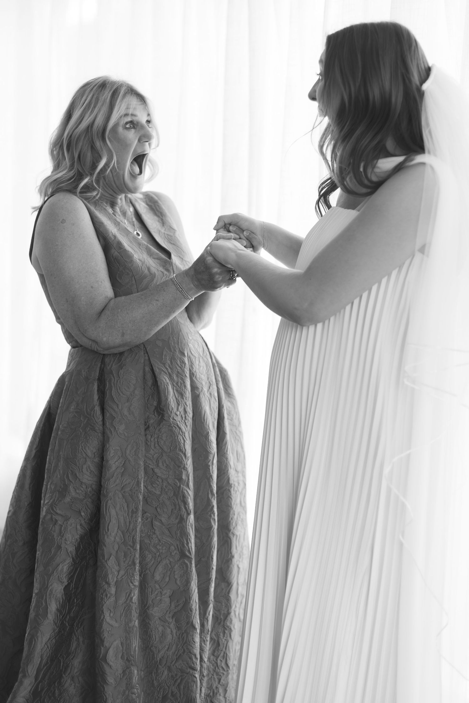 Sequential black and white images showing a dress being fastened in soft light by a window.