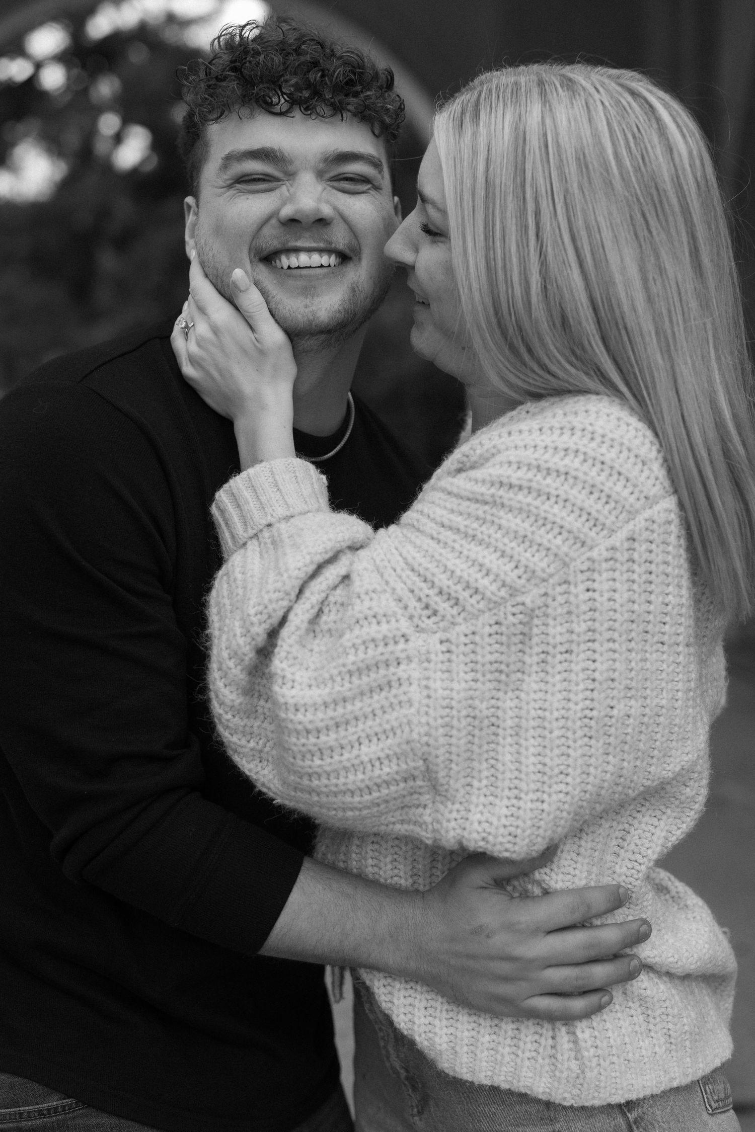 A couple shares intimate moments in black and white photos showing playful expressions and tender touches.