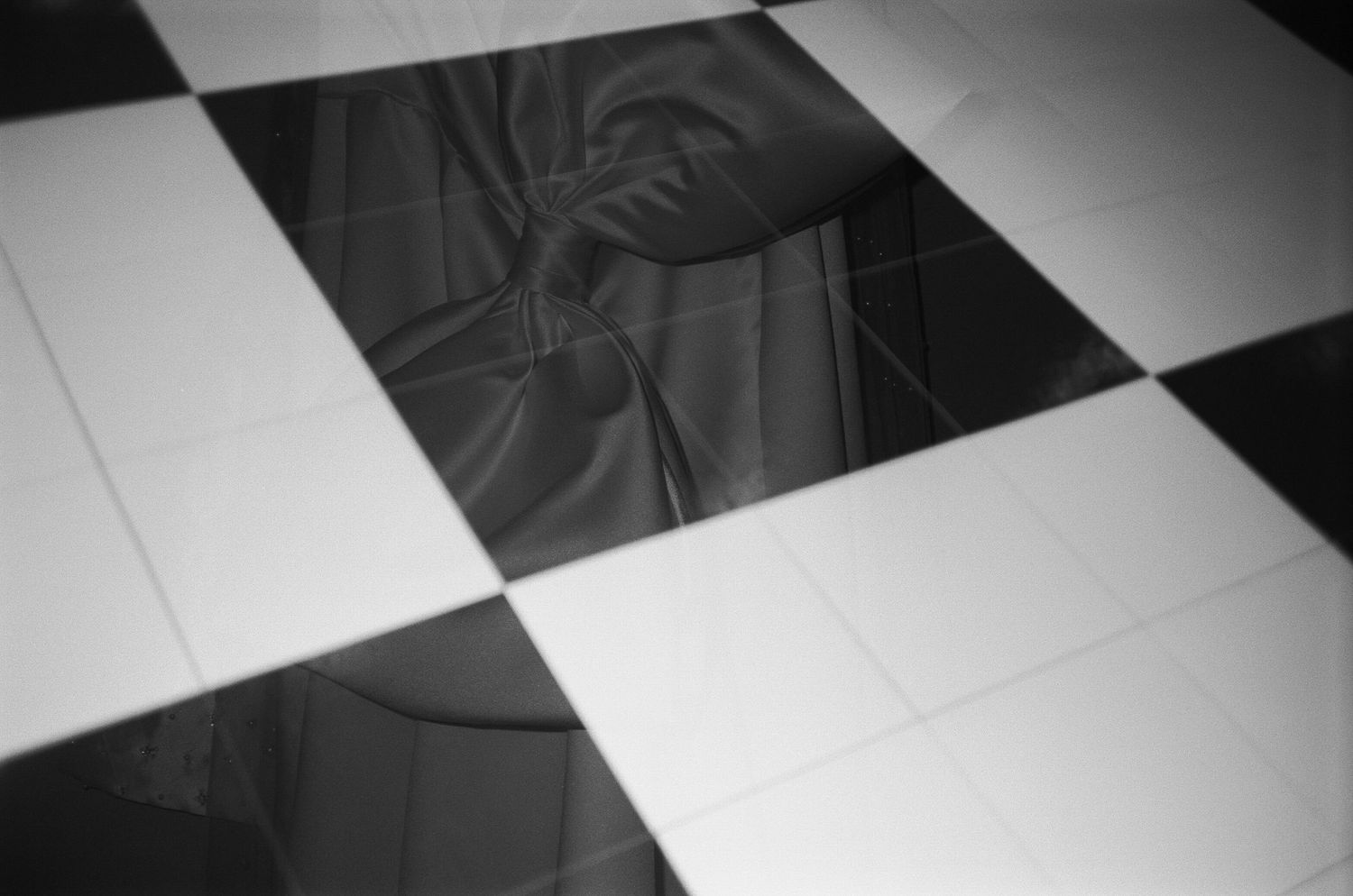 Black and white checkered dance floor pattern reflecting light at an event venue.