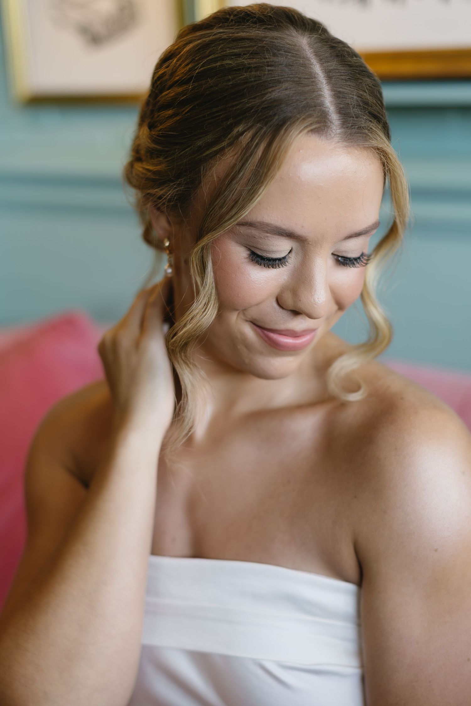 A close-up portrait showing gentle laughter and downturned eyes in a soft, natural light setting.