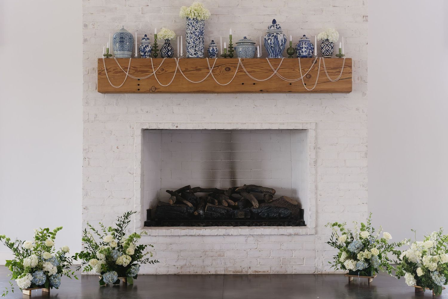 Modern wedding venue interior with white walls and decorative blue vases on wooden shelving.