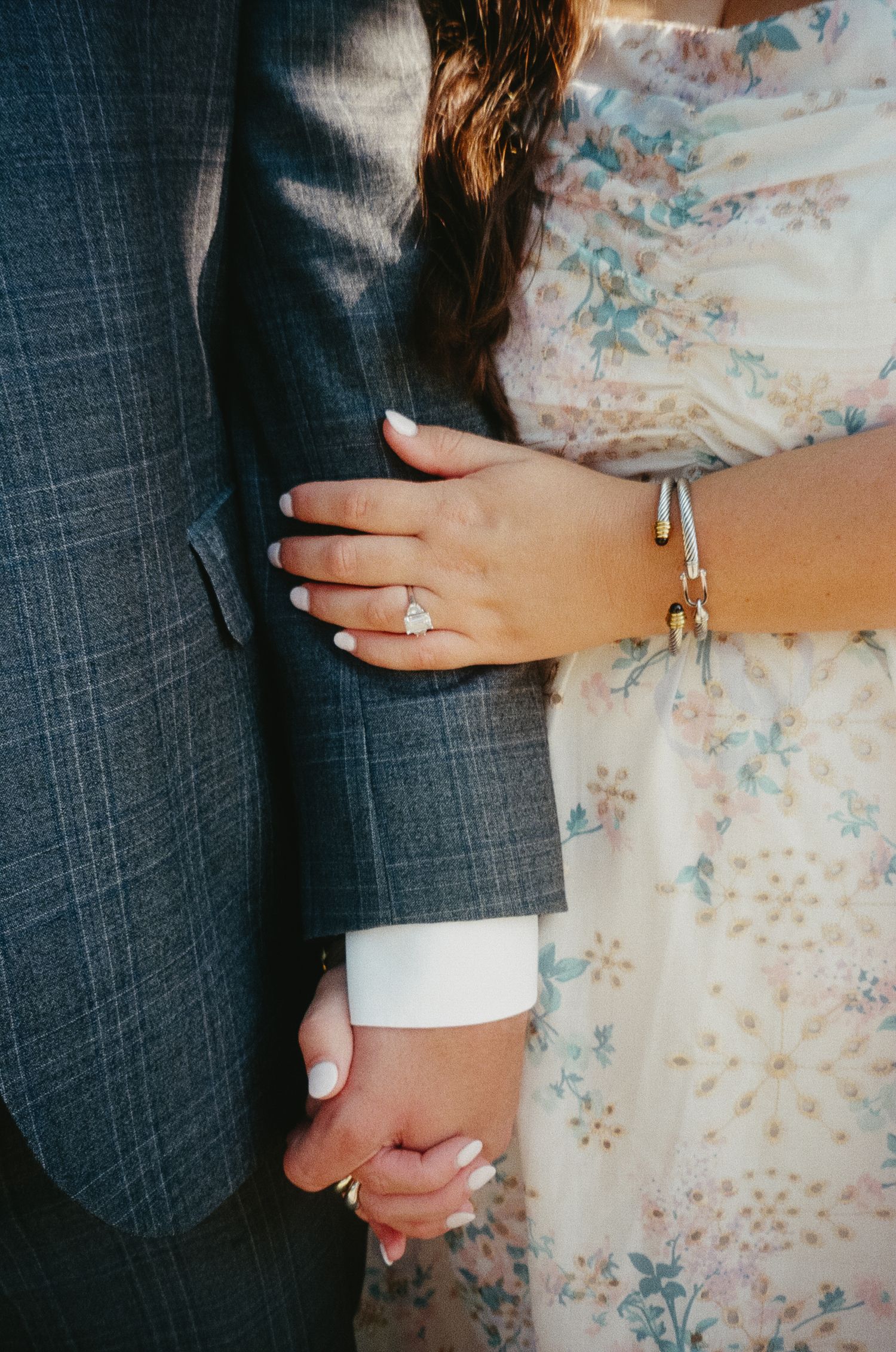 Close-up series of hands showing an engagement ring on a floral patterned background.
