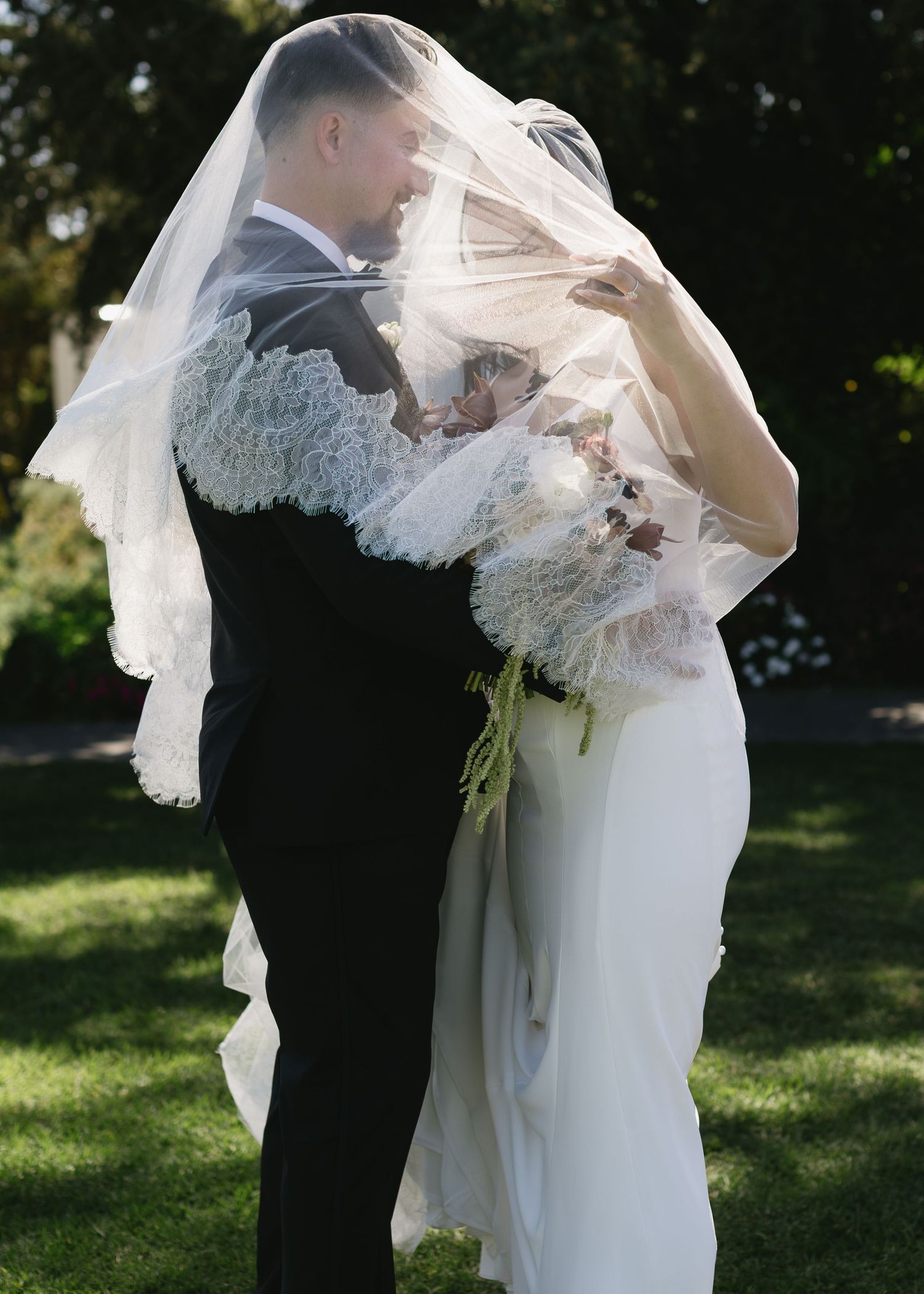 Romantic wedding sequence showing couple embracing under a delicate white veil in an outdoor garden setting.