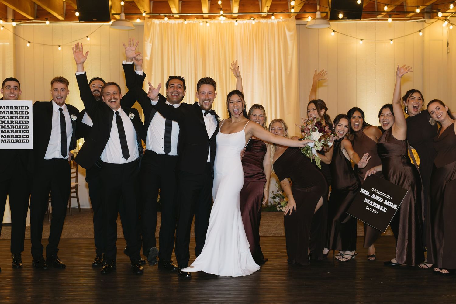 Wedding reception dance floor with guests and string lights overhead.