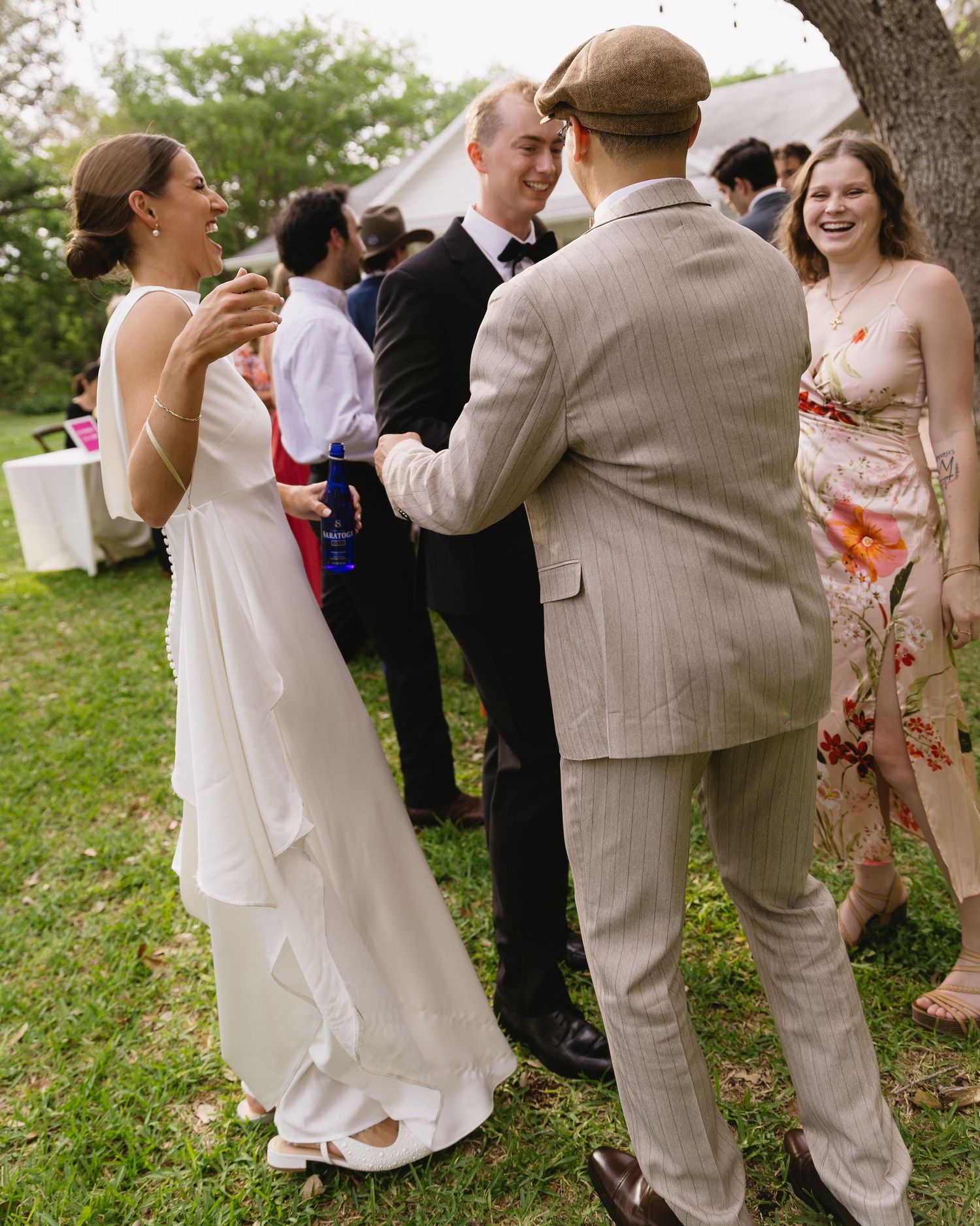 Wedding guests enjoying conversation during an outdoor garden reception.