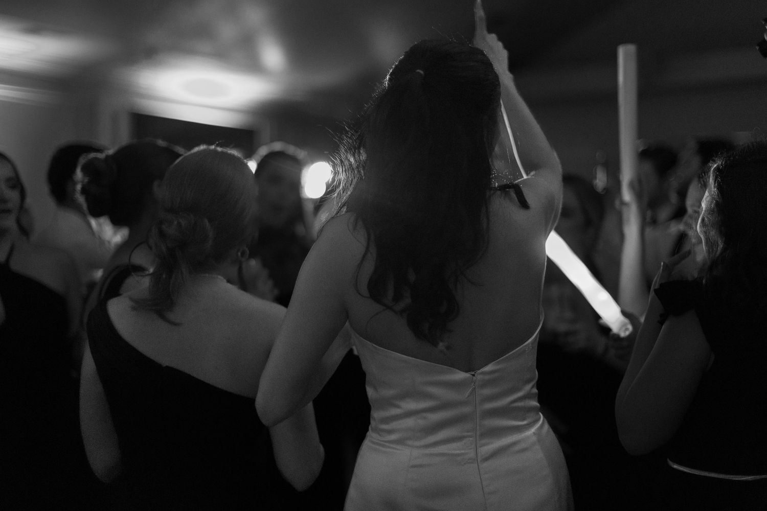 Dark silhouettes of people dancing at an evening celebration.