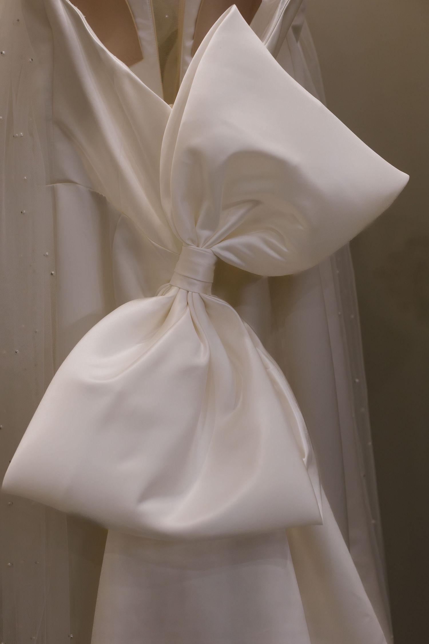Close-up of a large white bow detail on a wedding dress.