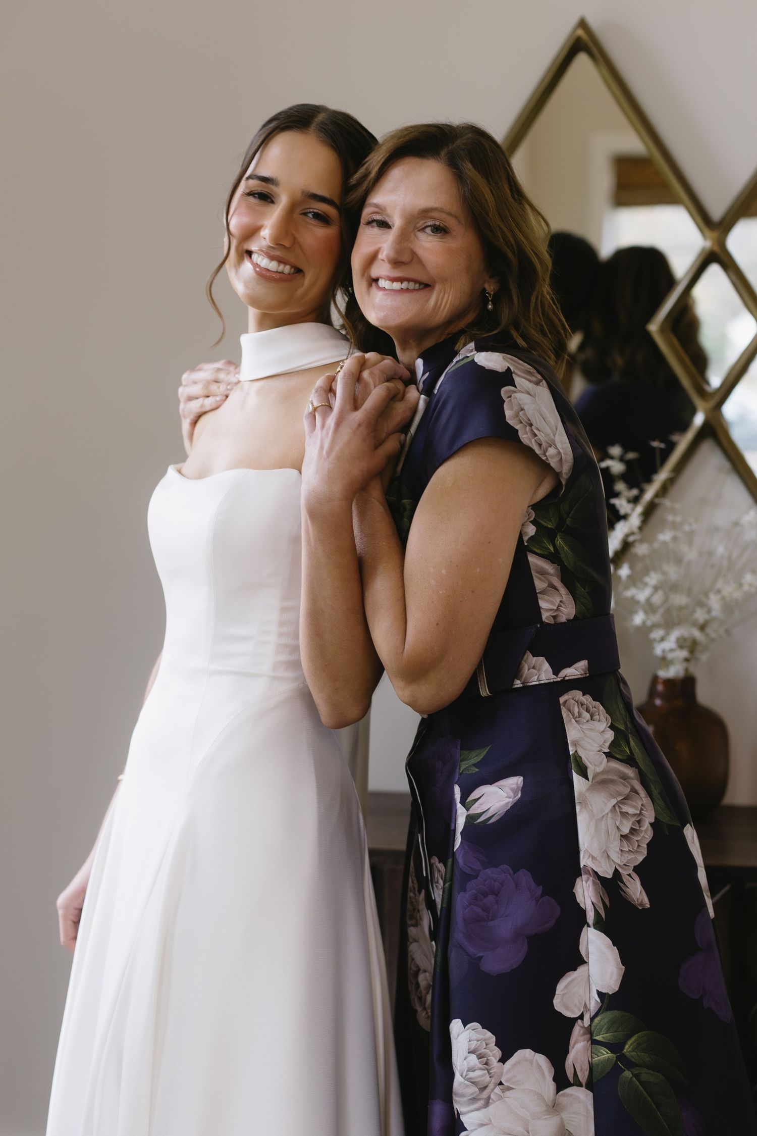 Wedding preparations showing white bridal gown and floral print dress in an intimate moment.