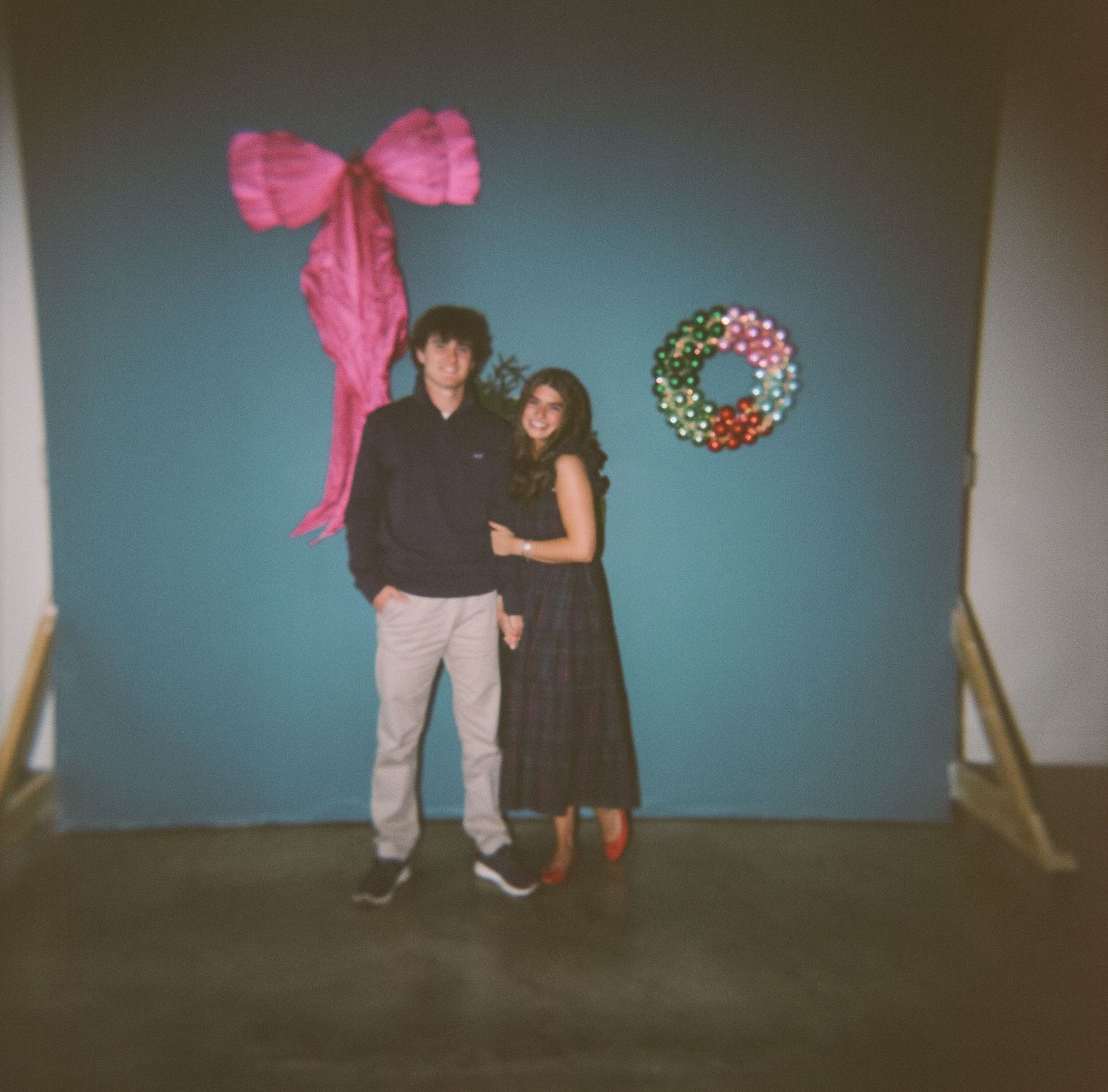 A series of vintage-style photos showing figures against a blue wall with a large pink bow decoration.