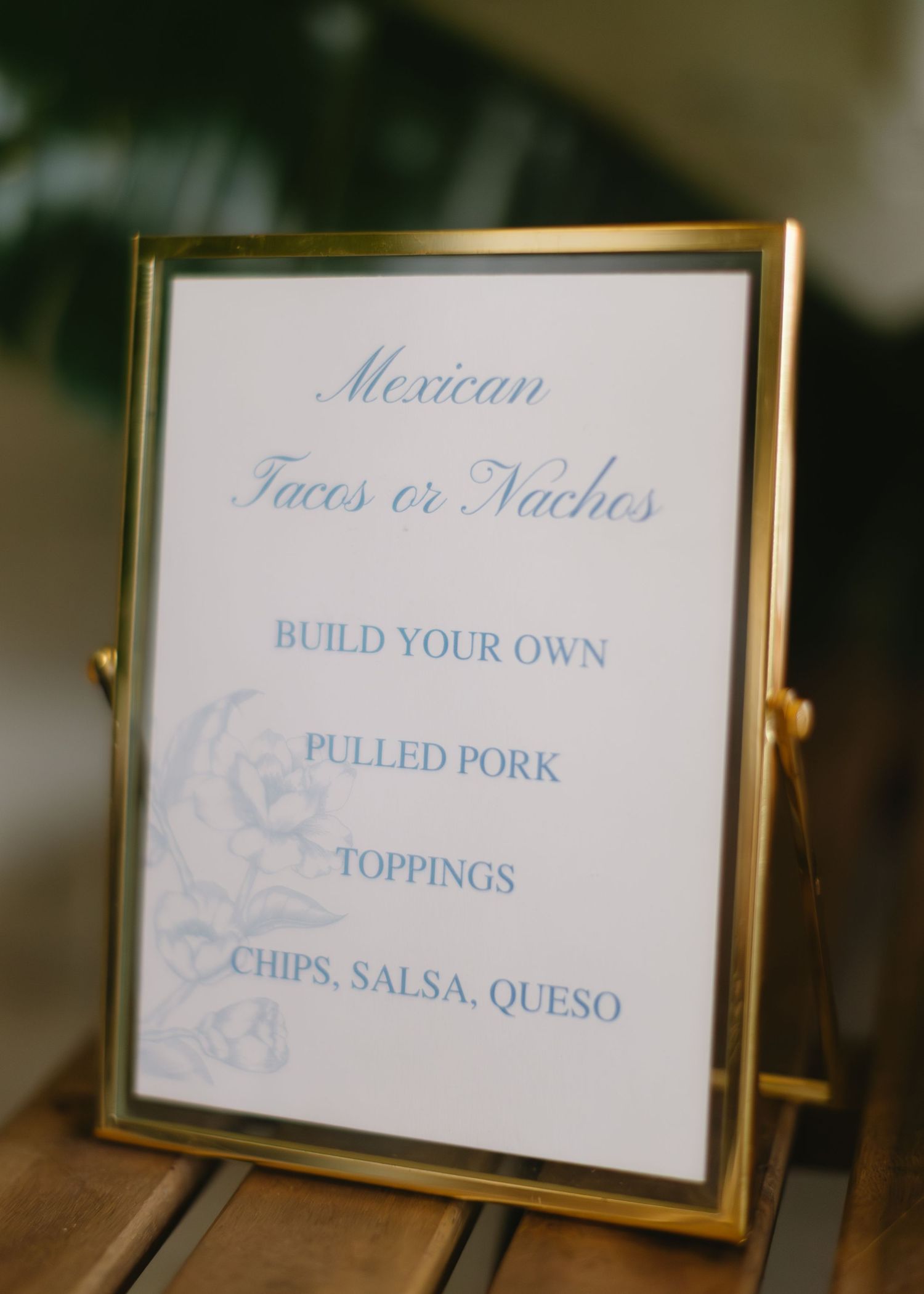 Gold-framed menu signs display Mexican food options and toppings.