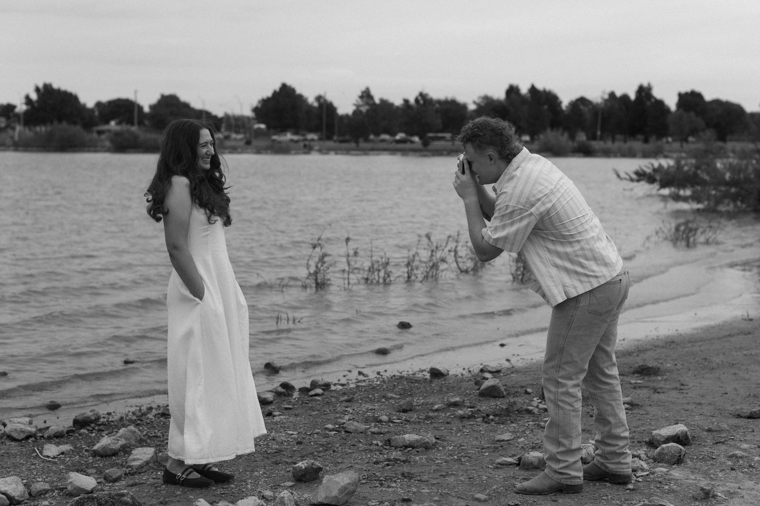 Wide landscape shots showing a couple's romantic moments along a scenic waterfront.
