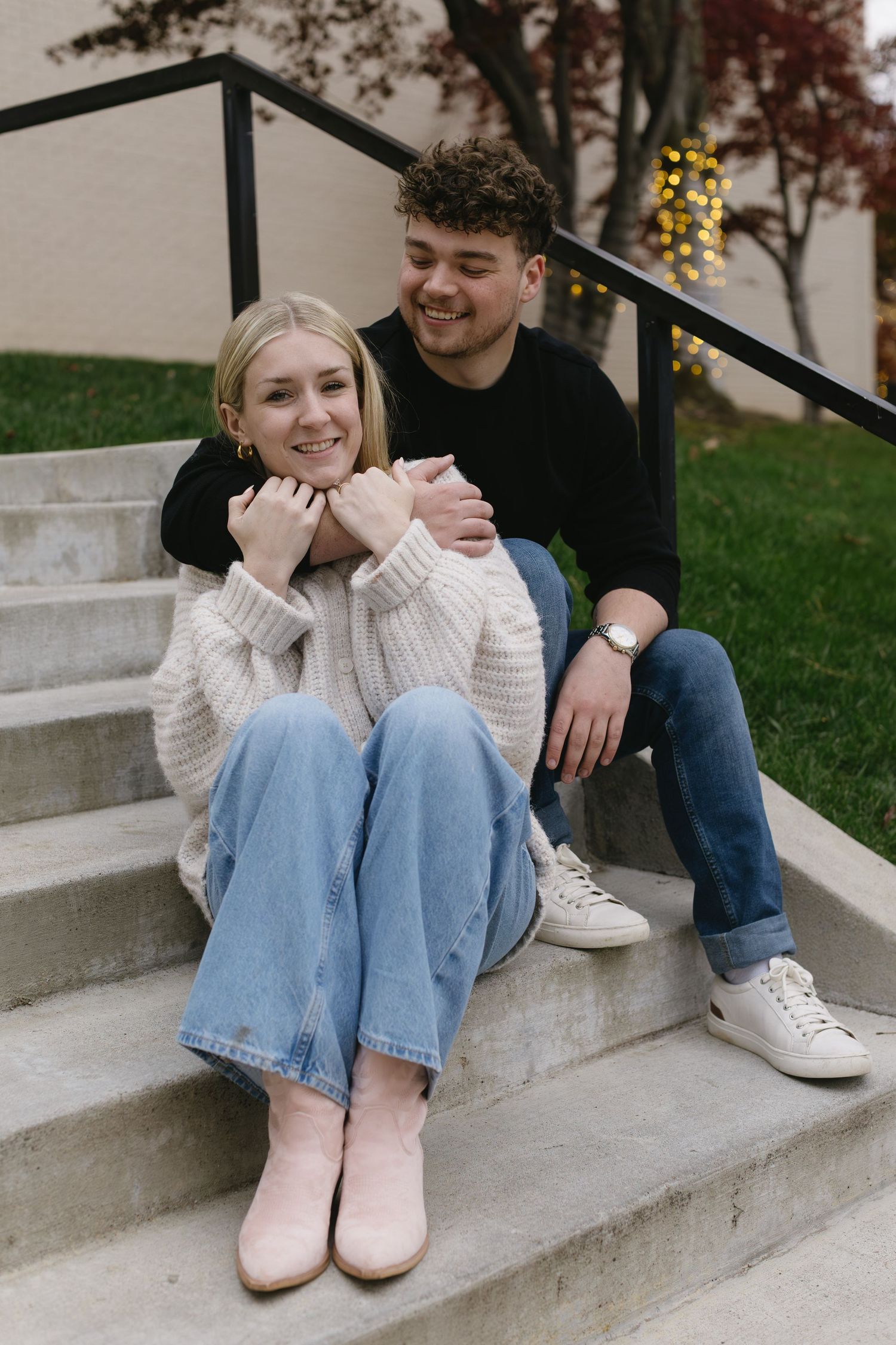 A couple sitting together on concrete steps sharing sweet moments.