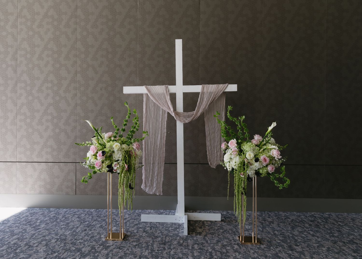 Modern cross displays with floral arrangements in minimalist church setting.