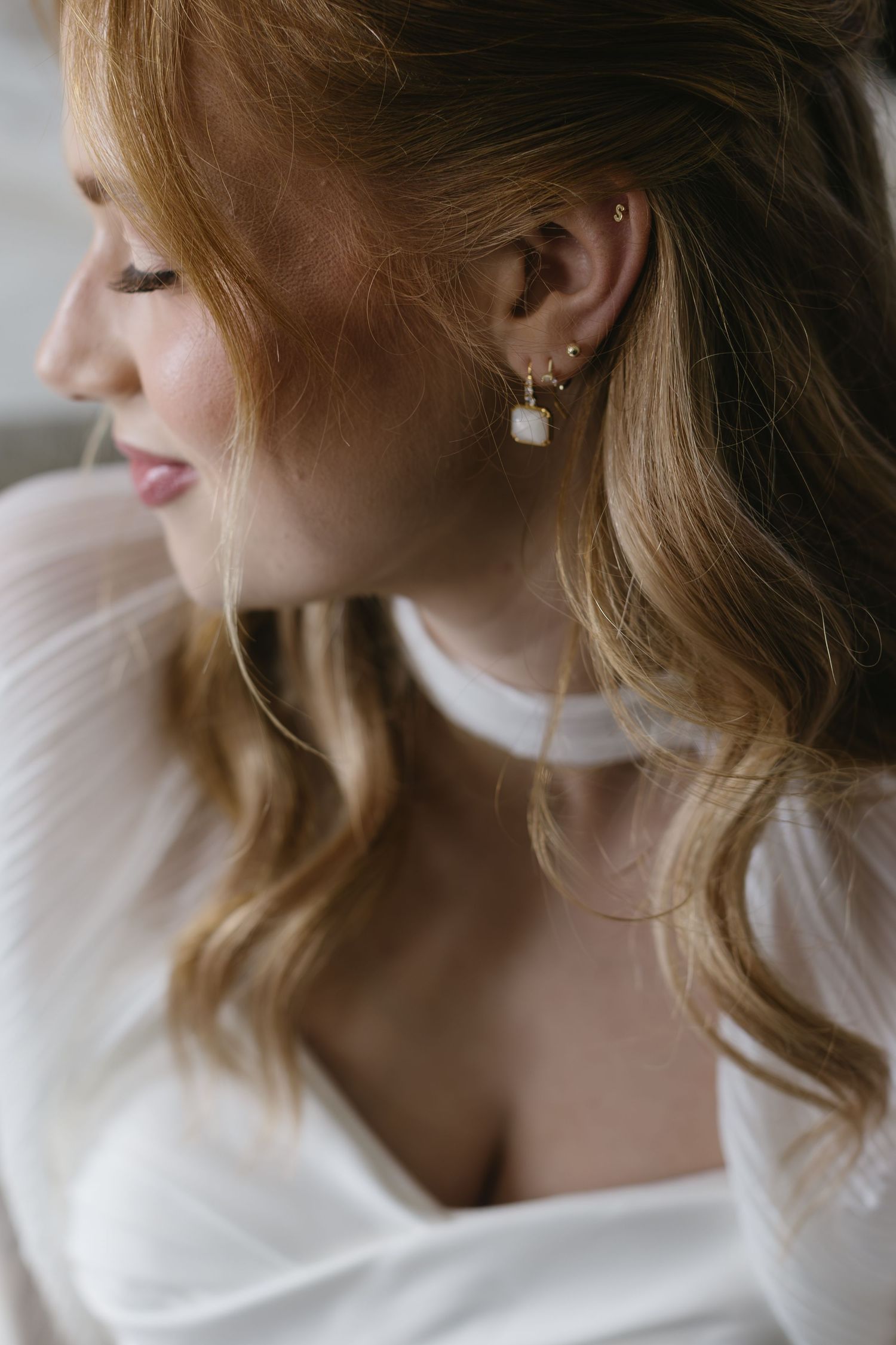 Elegant side profile shot showcasing delicate jewelry and soft fabric details.