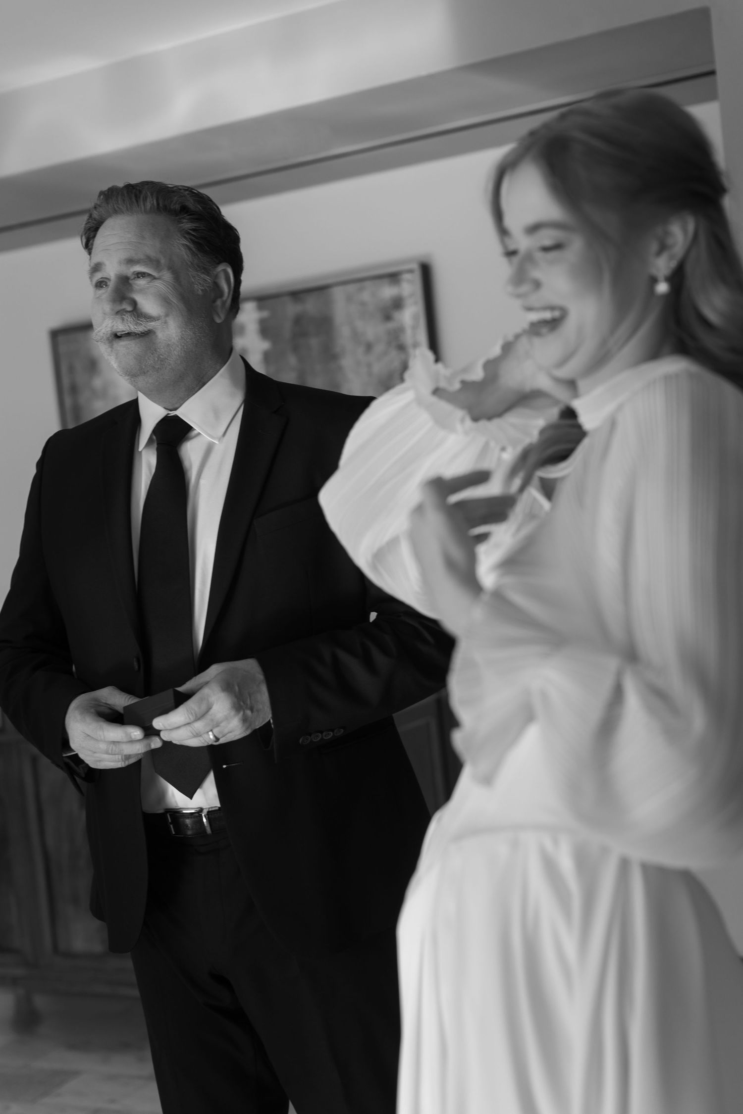 Black and white wedding photos showing tender moments between a bride in white dress and groom in suit.