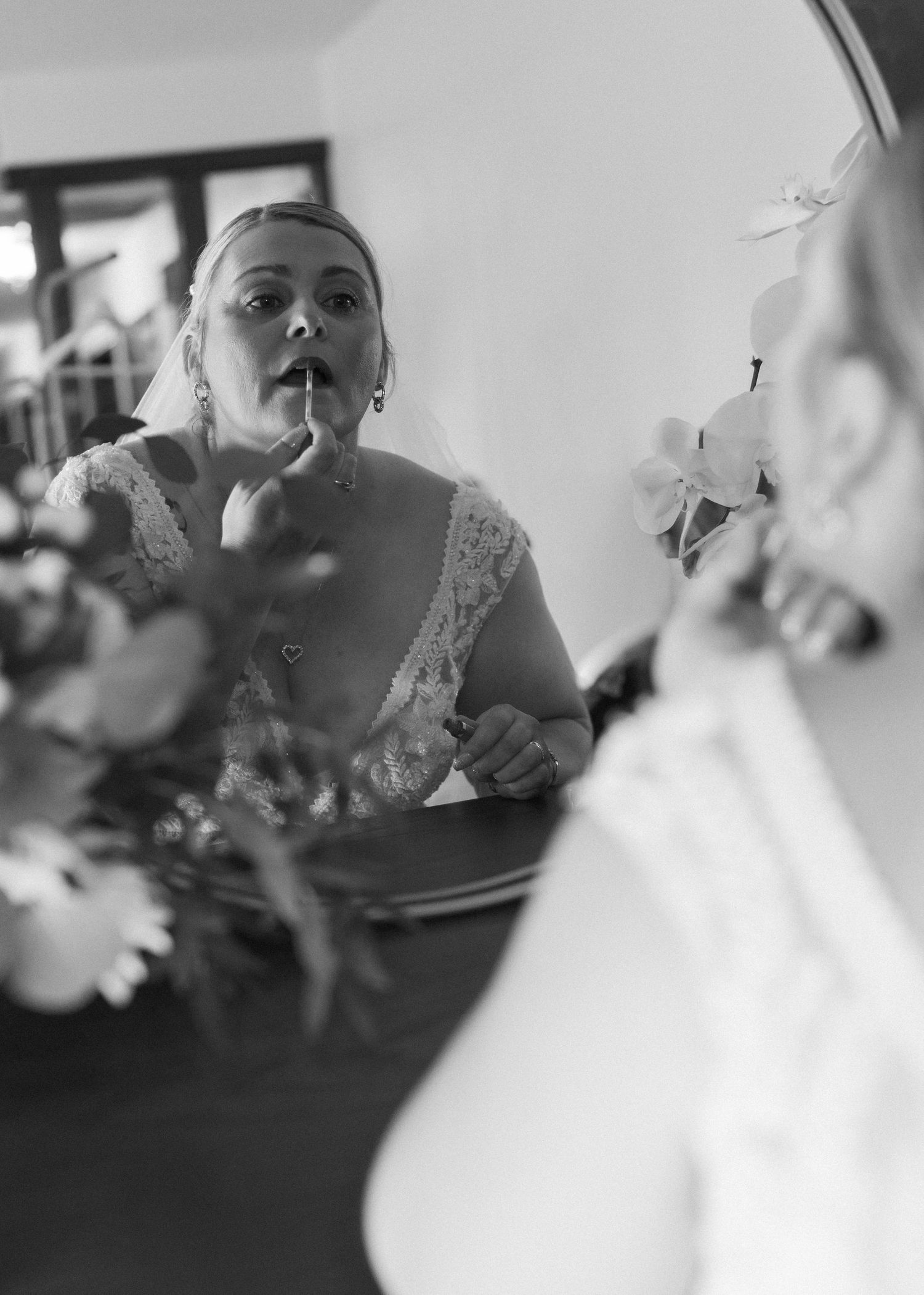 Black and white artistic reflection of wedding dress details in a mirror.