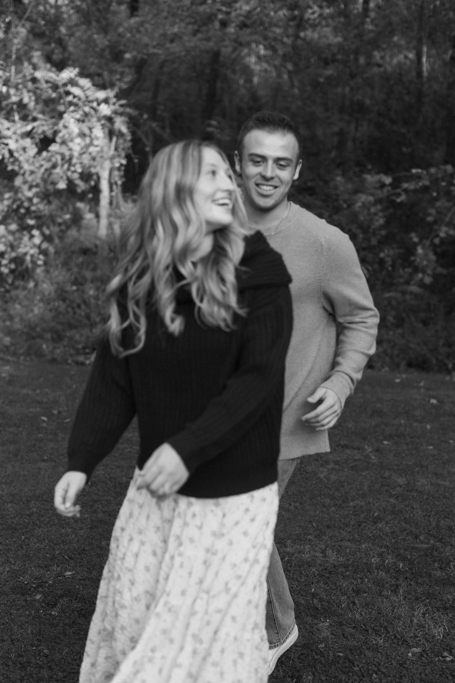 Playful couple laughing together during outdoor photo session.