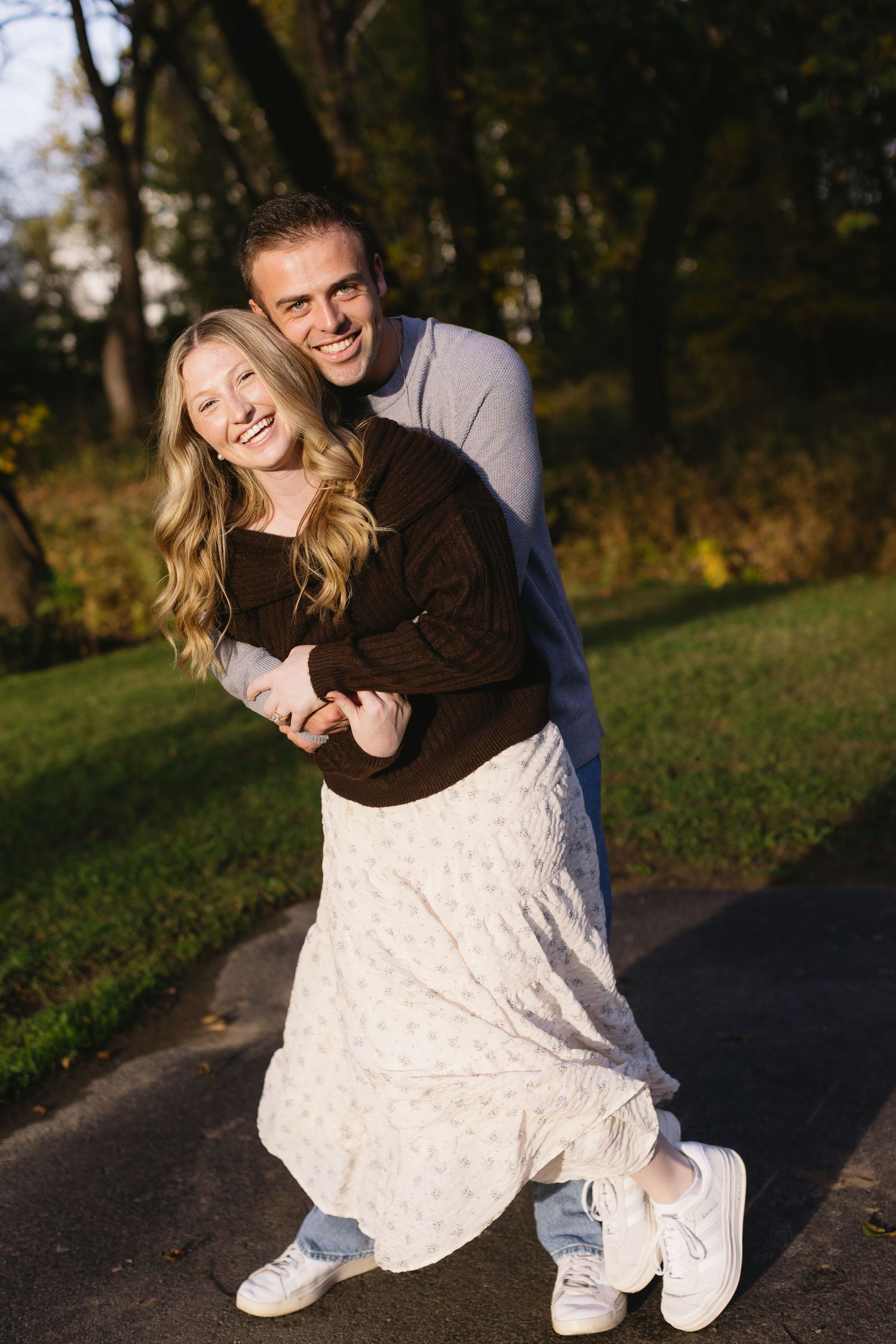 Playful couple shares joyful moments in golden afternoon sunlight.