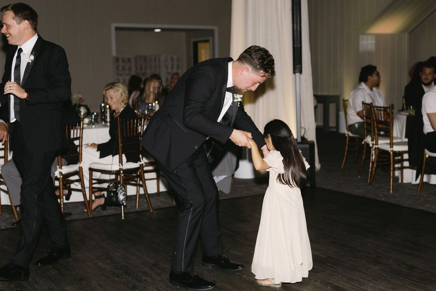 Wedding reception dance floor with couples dancing in dim lighting.