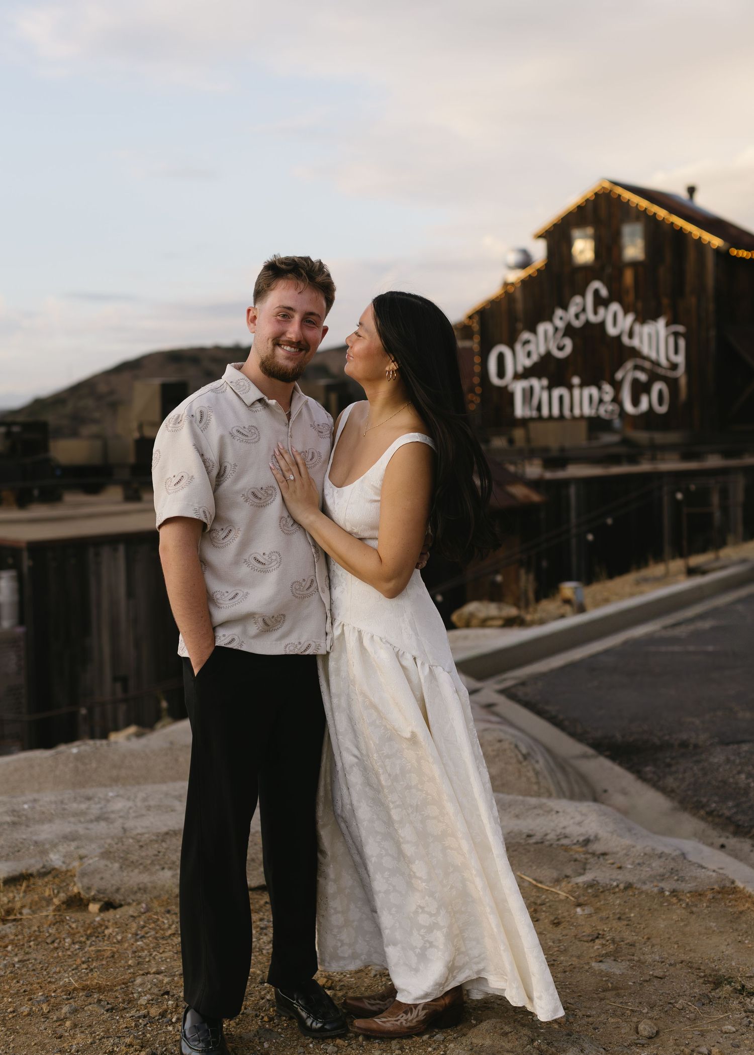 A couple shares a romantic moment at a rustic industrial venue during a wedding photoshoot.