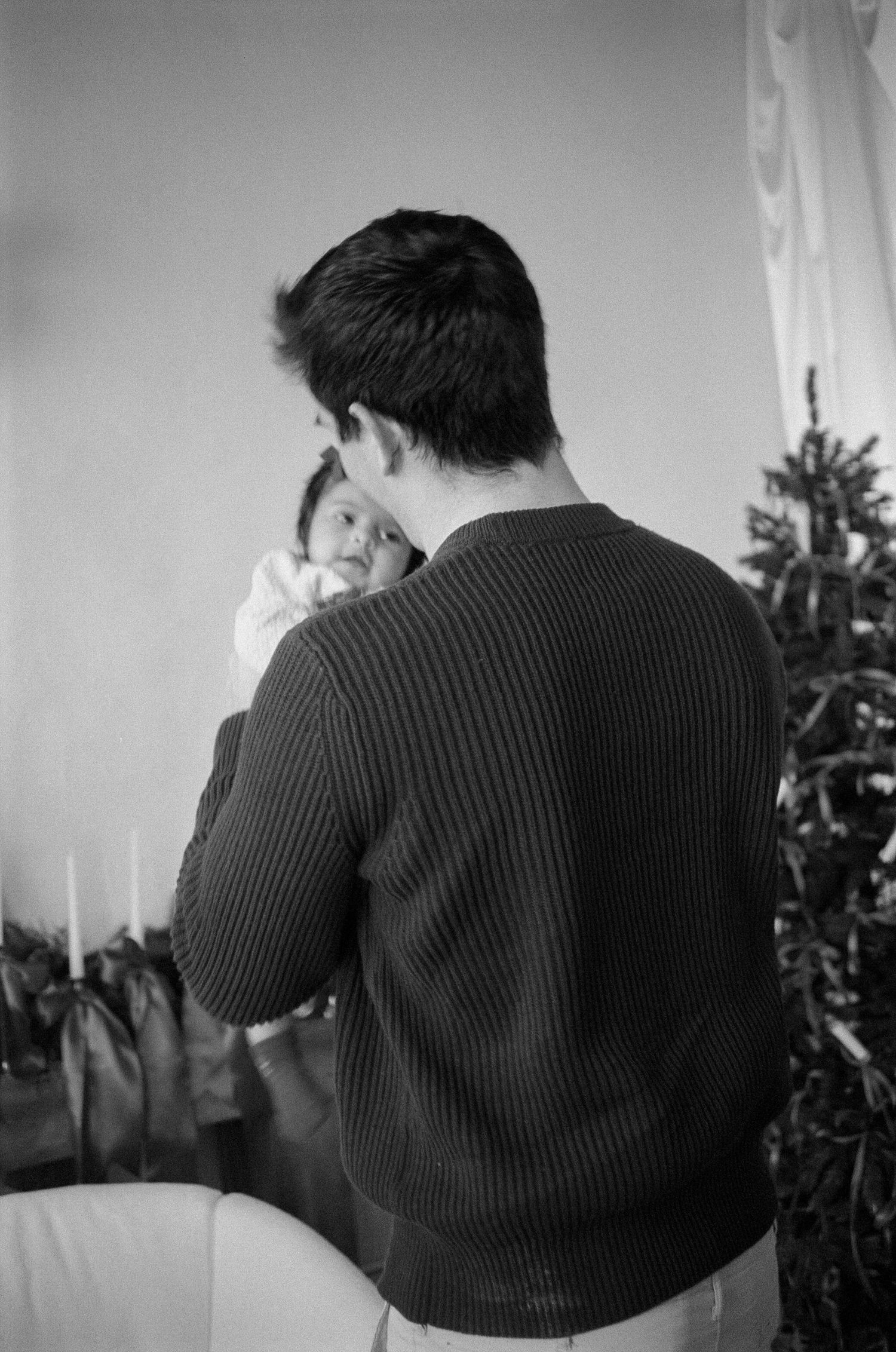A sequence of black and white photos showing someone in a dark sweater turning away from the camera.