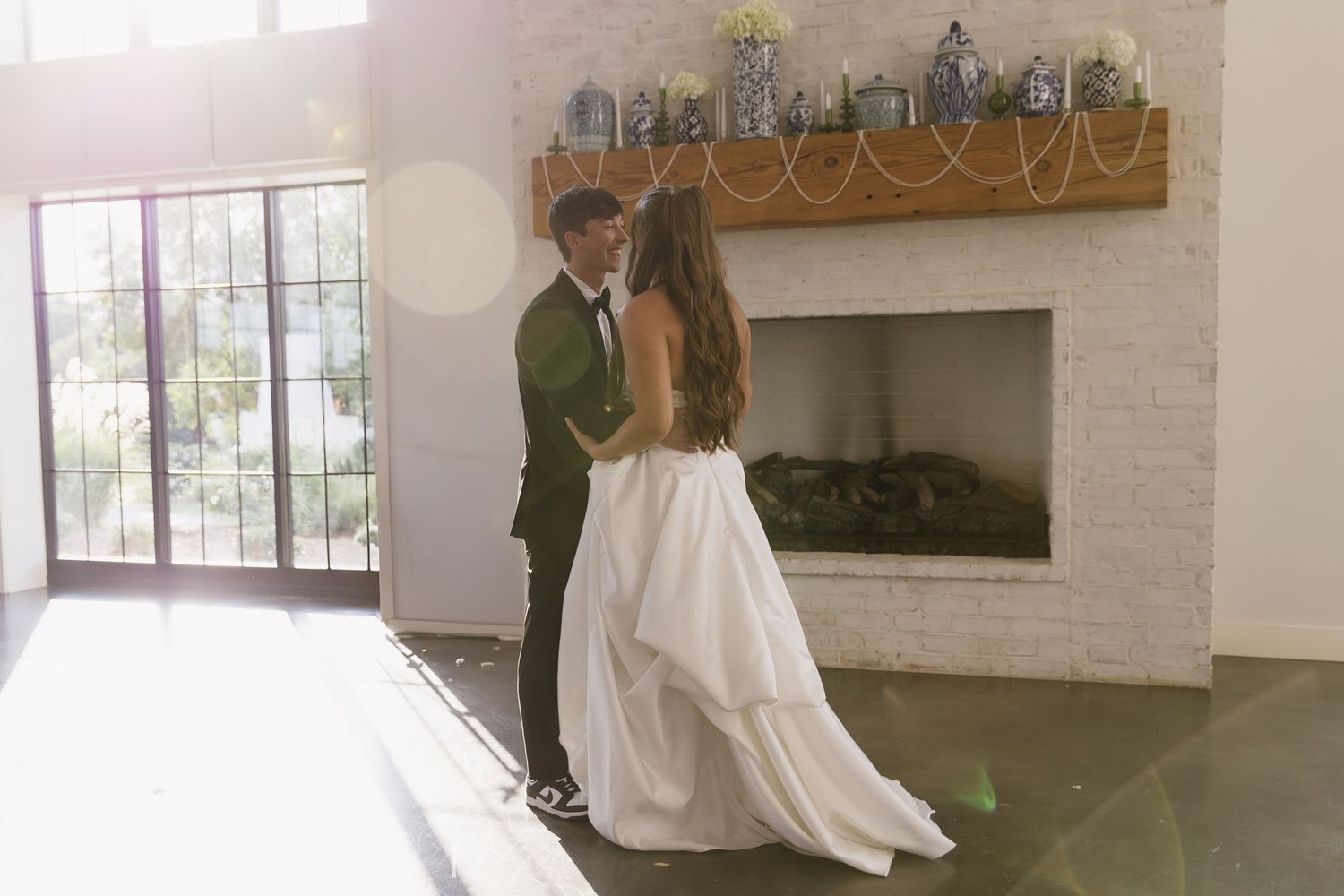 Interior view of a bright modern wedding venue with white walls and exposed wooden beams.