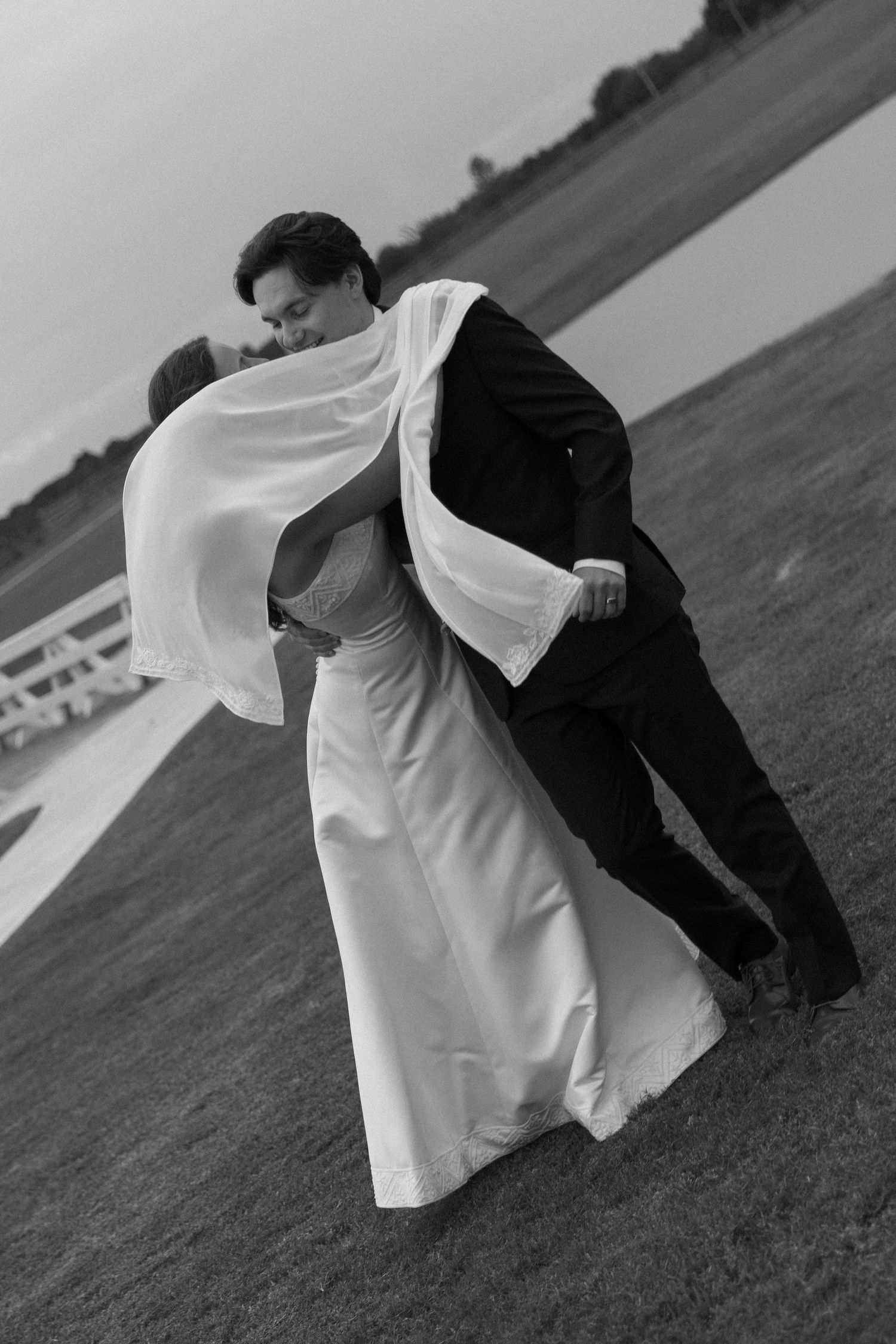 Dynamic black and white photo series captures flowing white dress movement against dark jacket in outdoor wedding dance sequence.