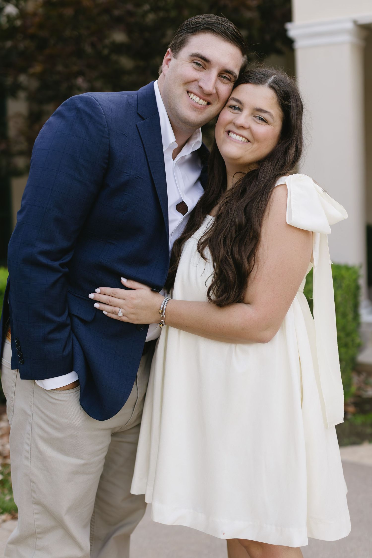 A couple shares a joyful moment together while posing in formal attire.