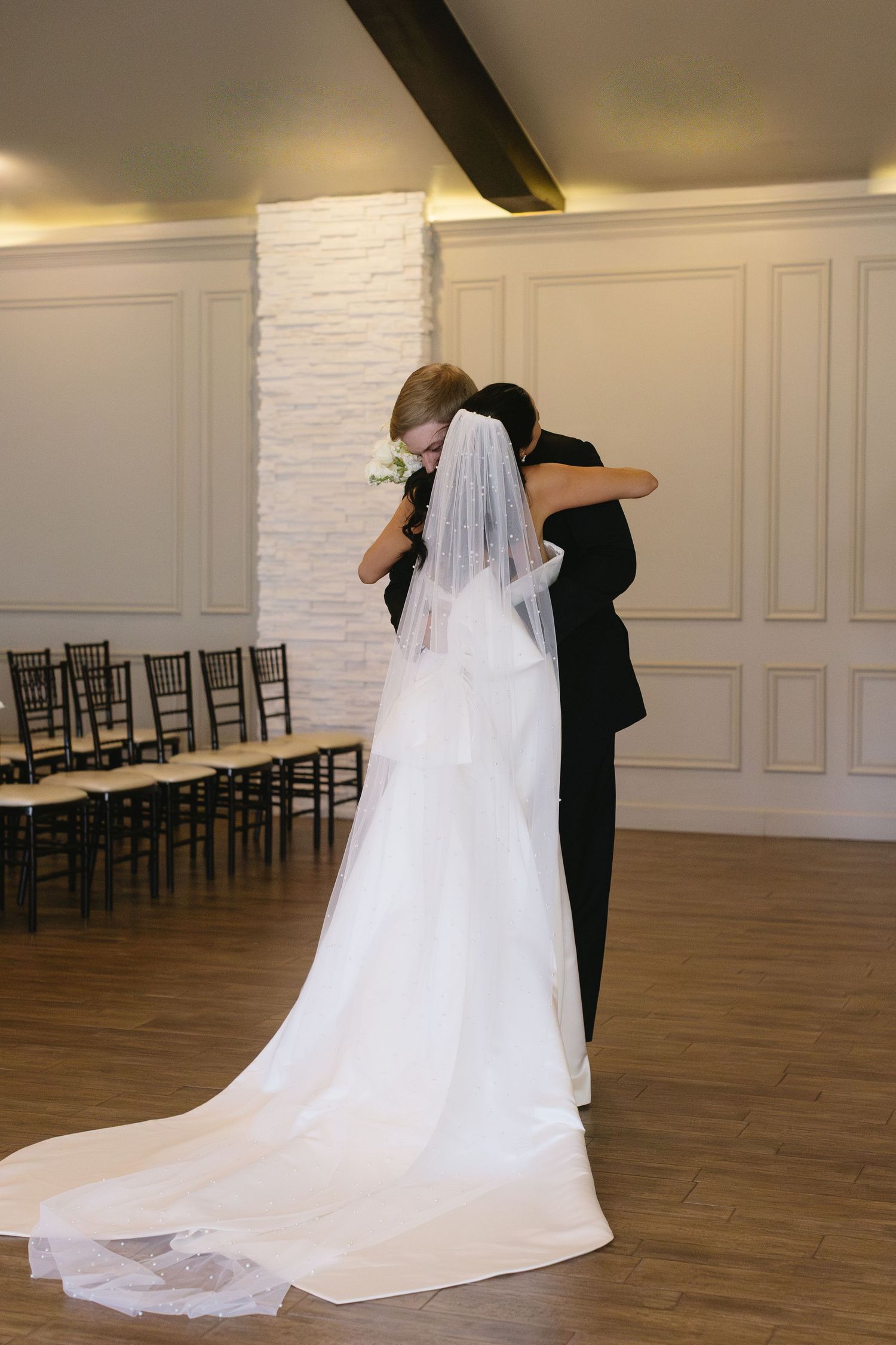 Couple sharing intimate dance moments in an elegant white-walled reception venue.