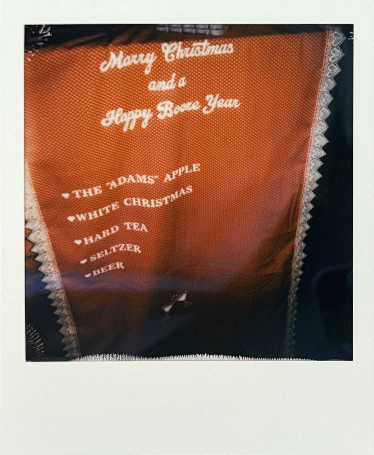 Holiday menu sign with Christmas and New Year greetings in orange lighting.