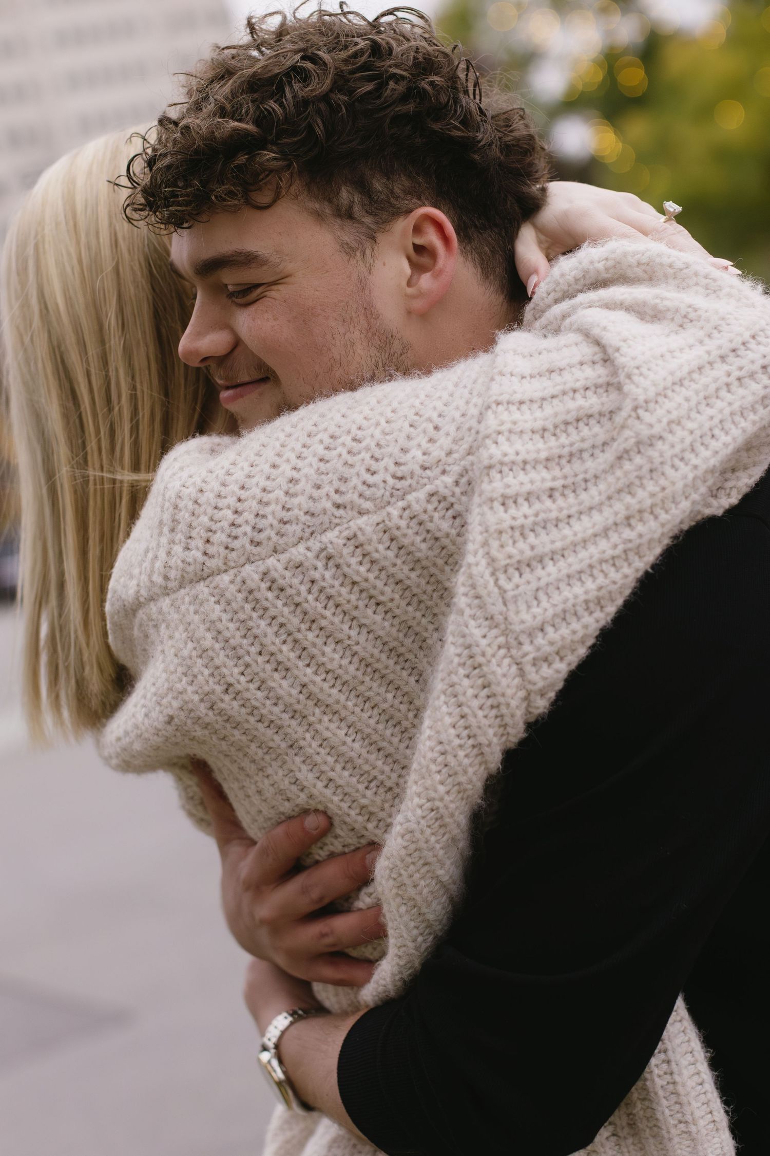 Autumn photoshoot of couple in matching sweaters showing affection.