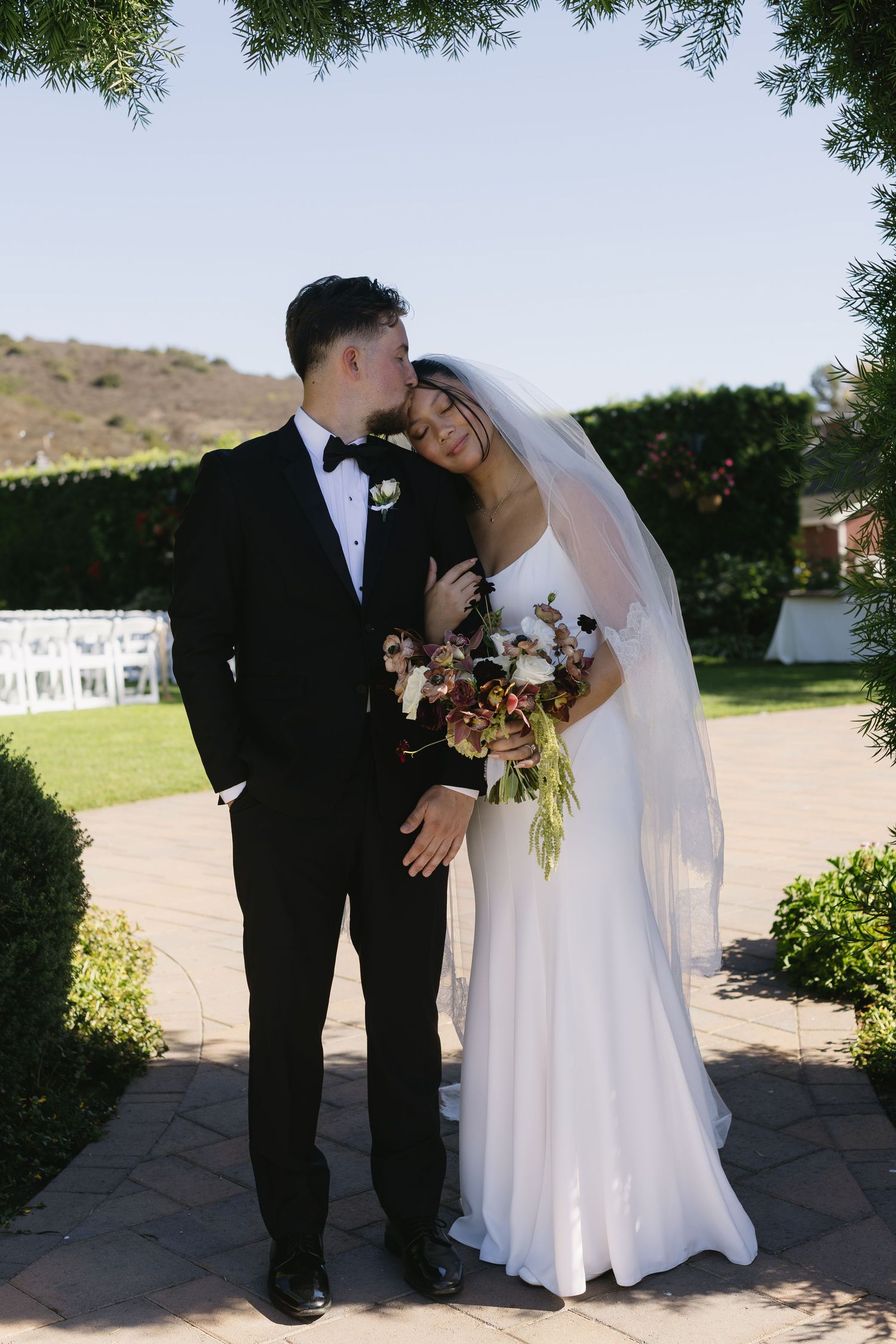 Wedding couple sharing an intimate moment outdoors on their special day.