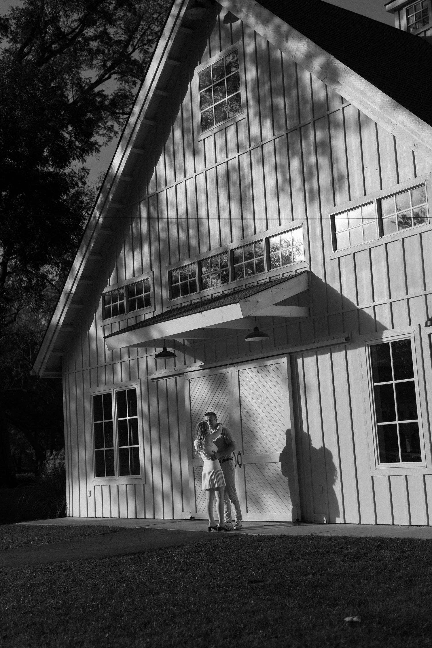 Black and white series showing silhouettes against a modern white barn structure.