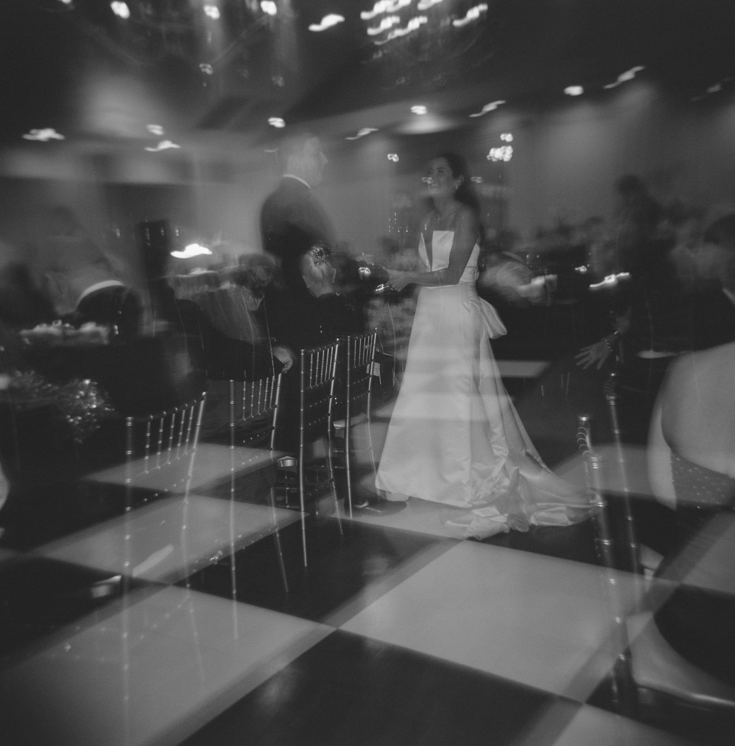 Black and white photo of a dance floor with ethereal motion blur effects.