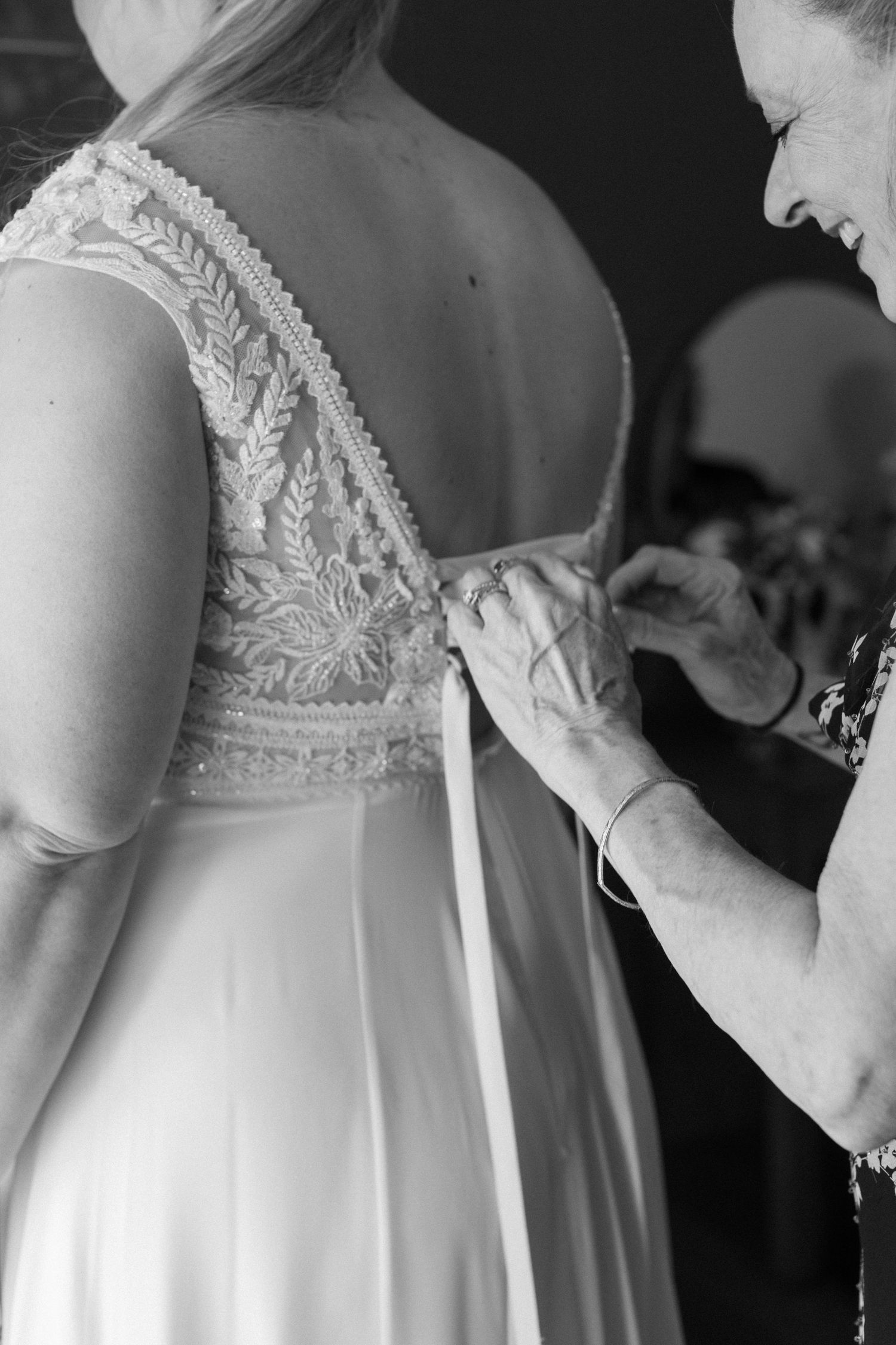 Close-up details of white lace wedding dress bodices showing delicate embroidery and straps.