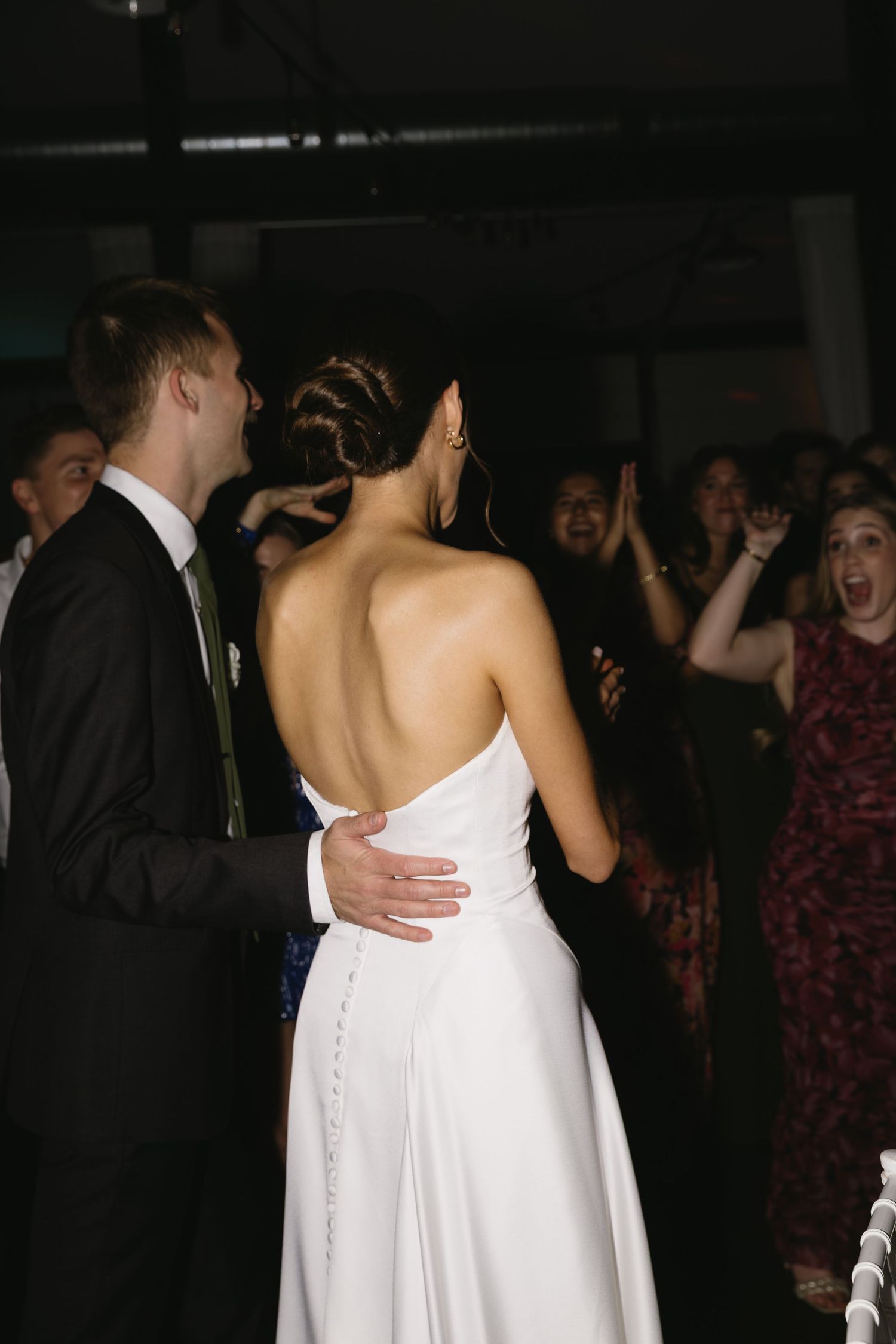 A couple in formal wedding attire dancing at their reception.