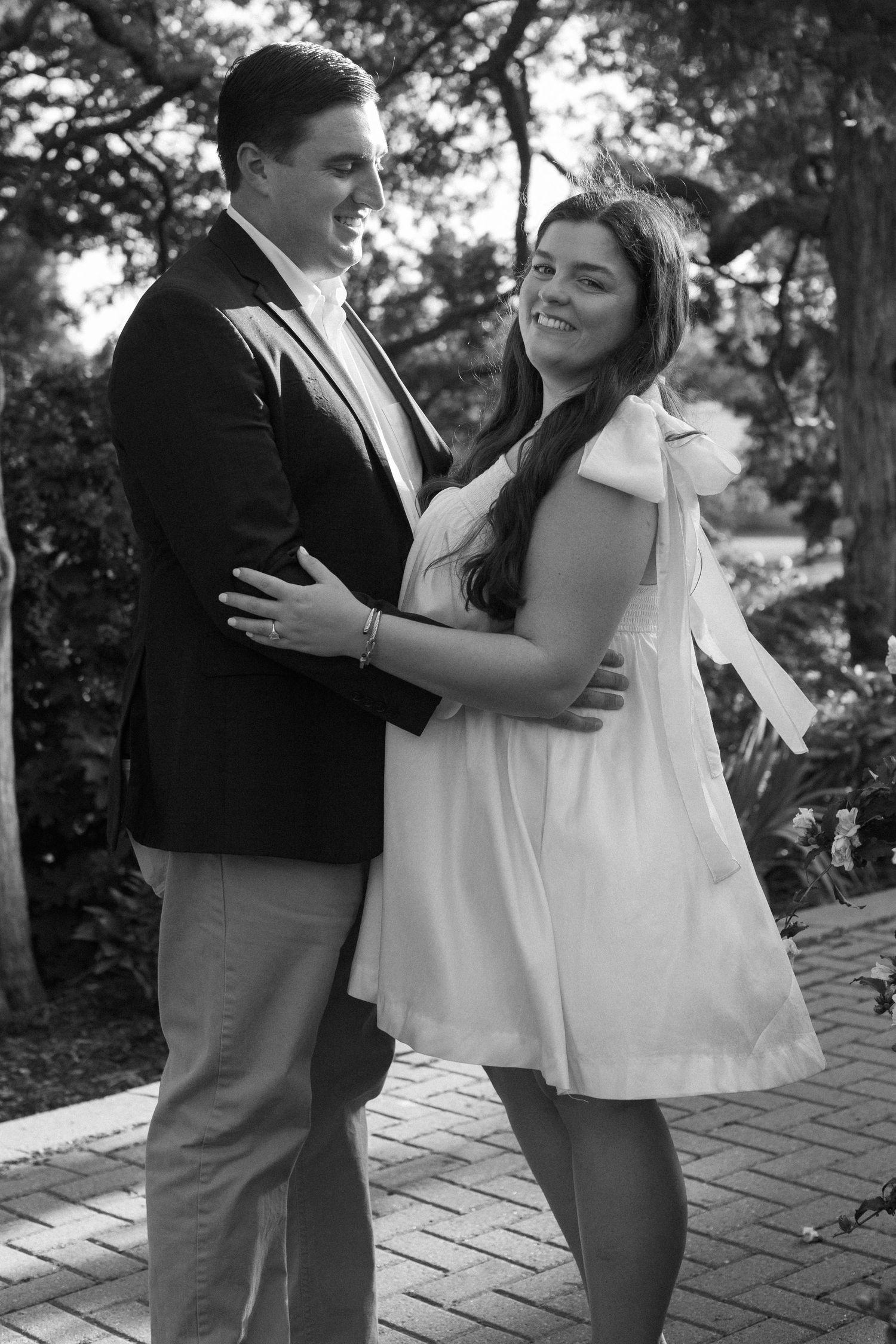 Black and white images of a couple in formal wear dancing and embracing on a brick patio.