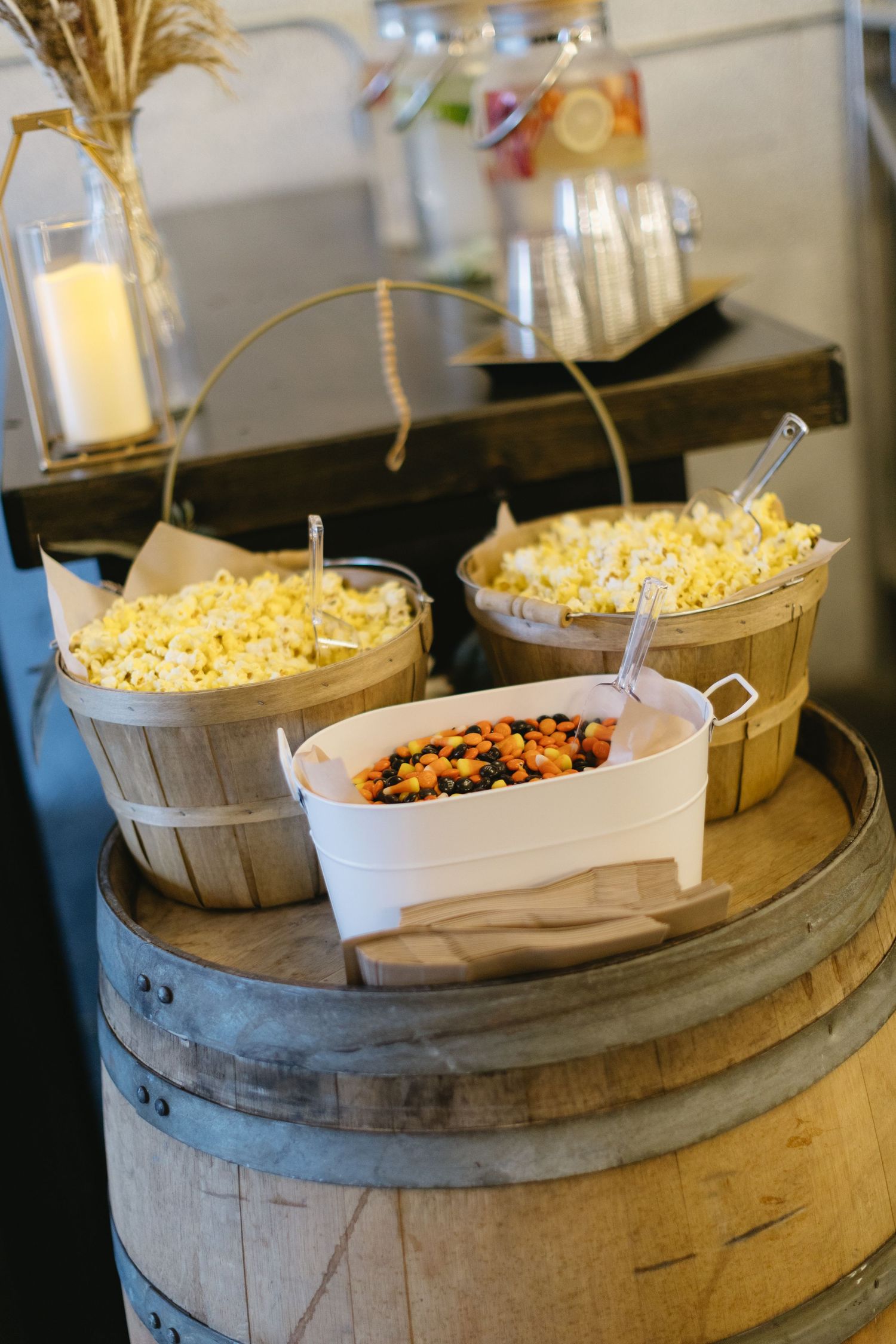 Popcorn and snacks displayed in rustic baskets on top of a wooden barrel.