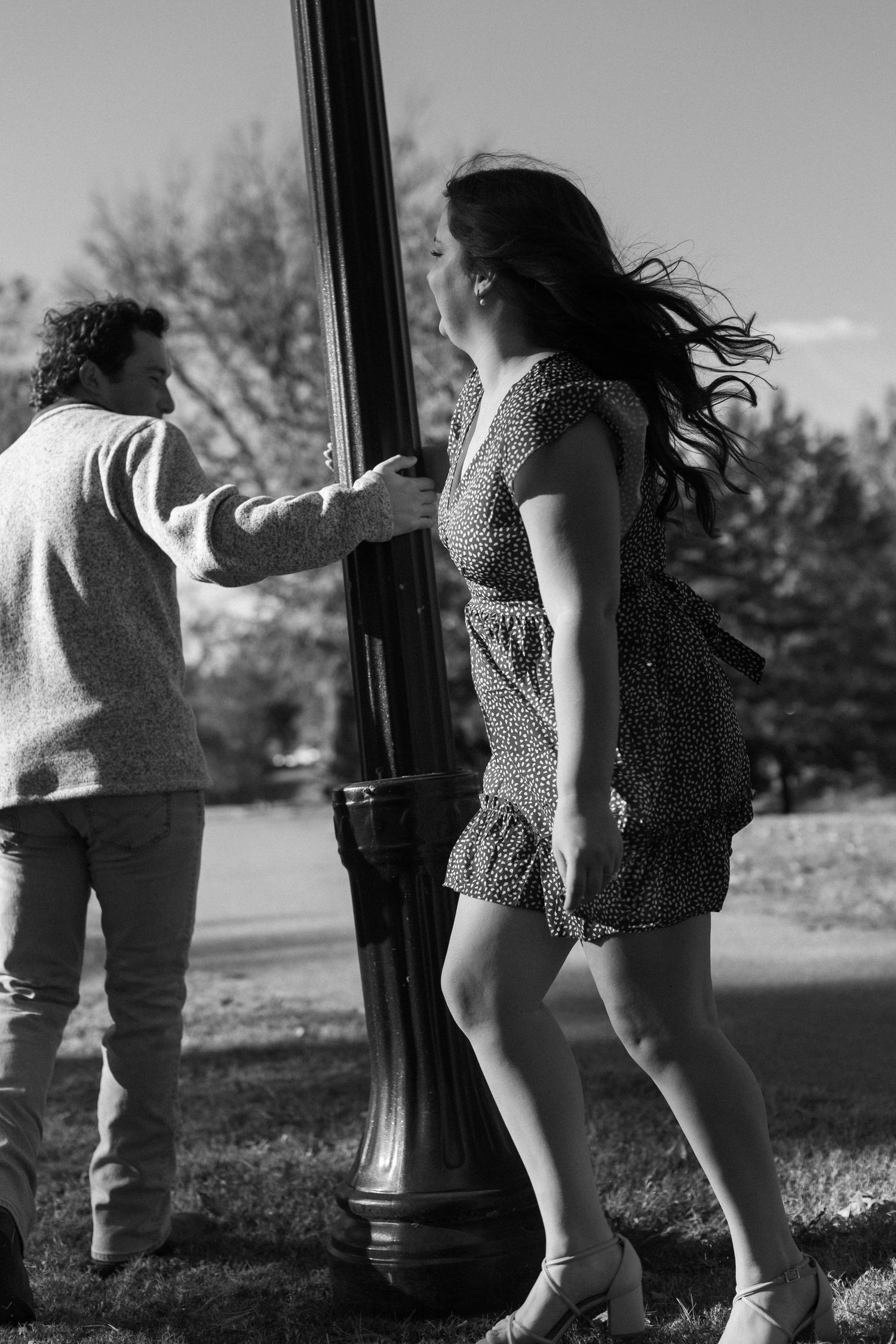 Black and white photo series of two people walking together near a vintage lamppost.