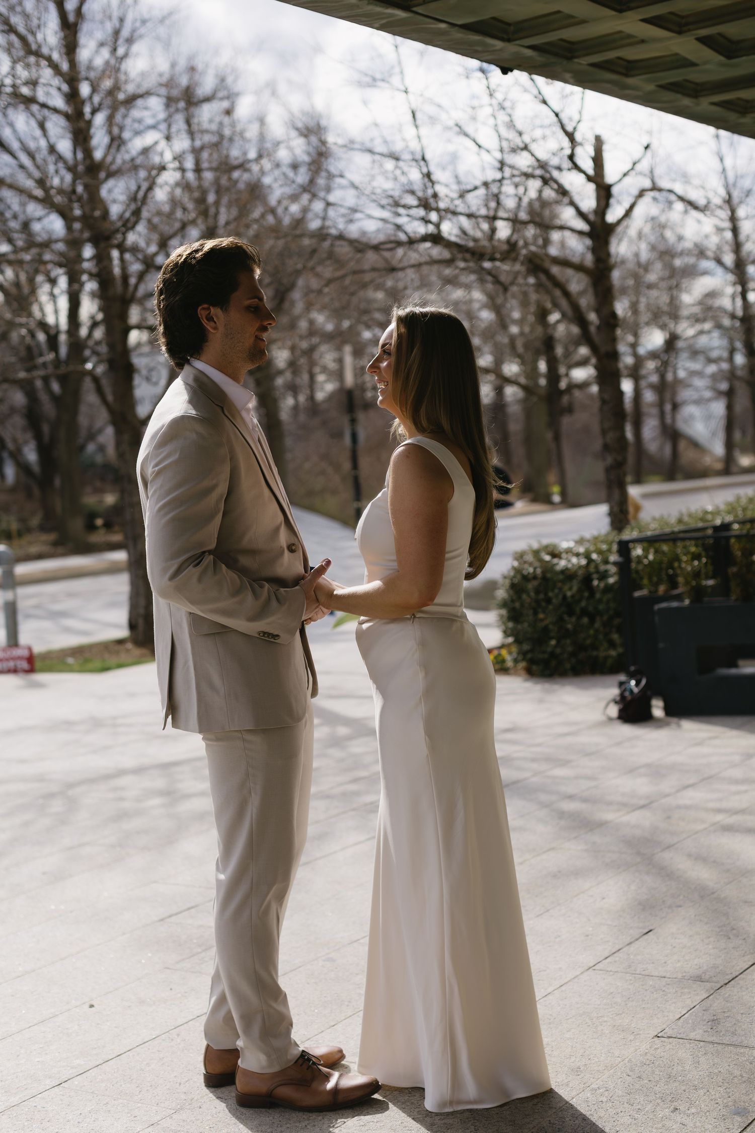 A couple shares a meaningful moment outdoors while wearing coordinating formal attire.
