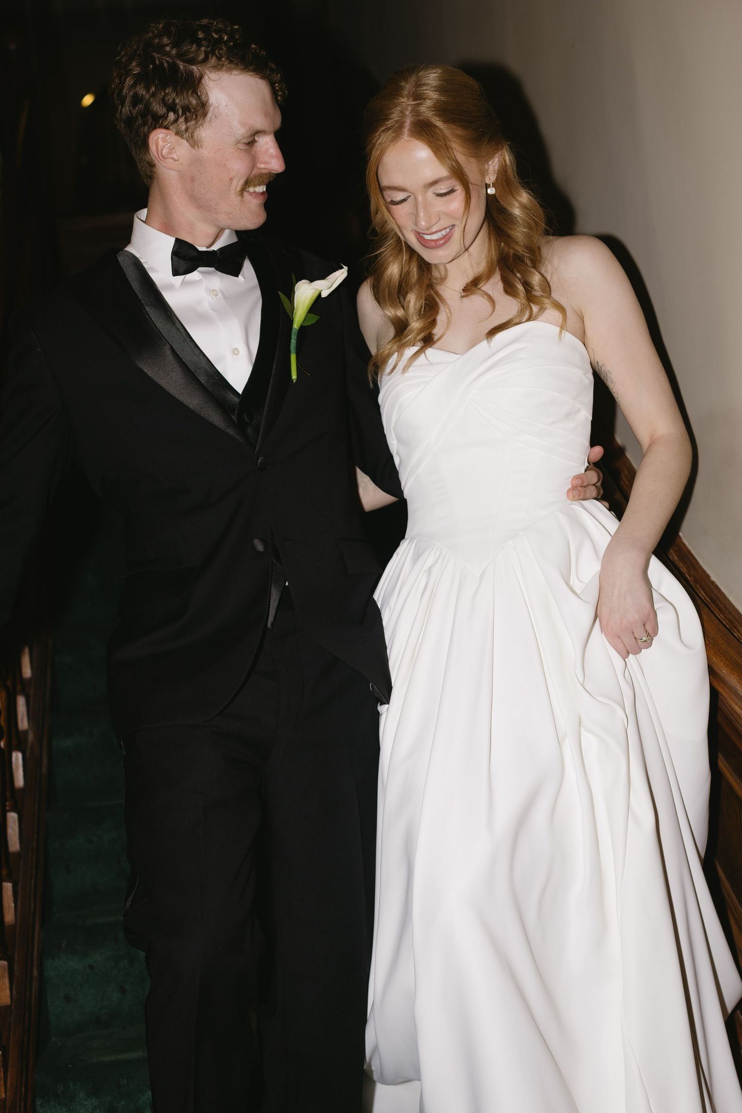 A candid moment of newlyweds laughing together during their wedding reception.