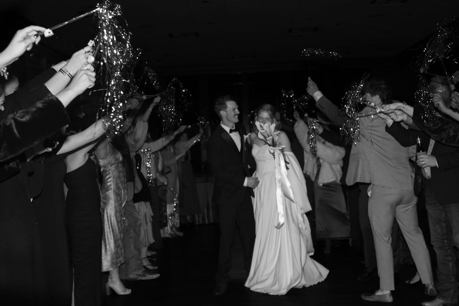 Wedding celebration silhouettes dancing in dark reception venue.