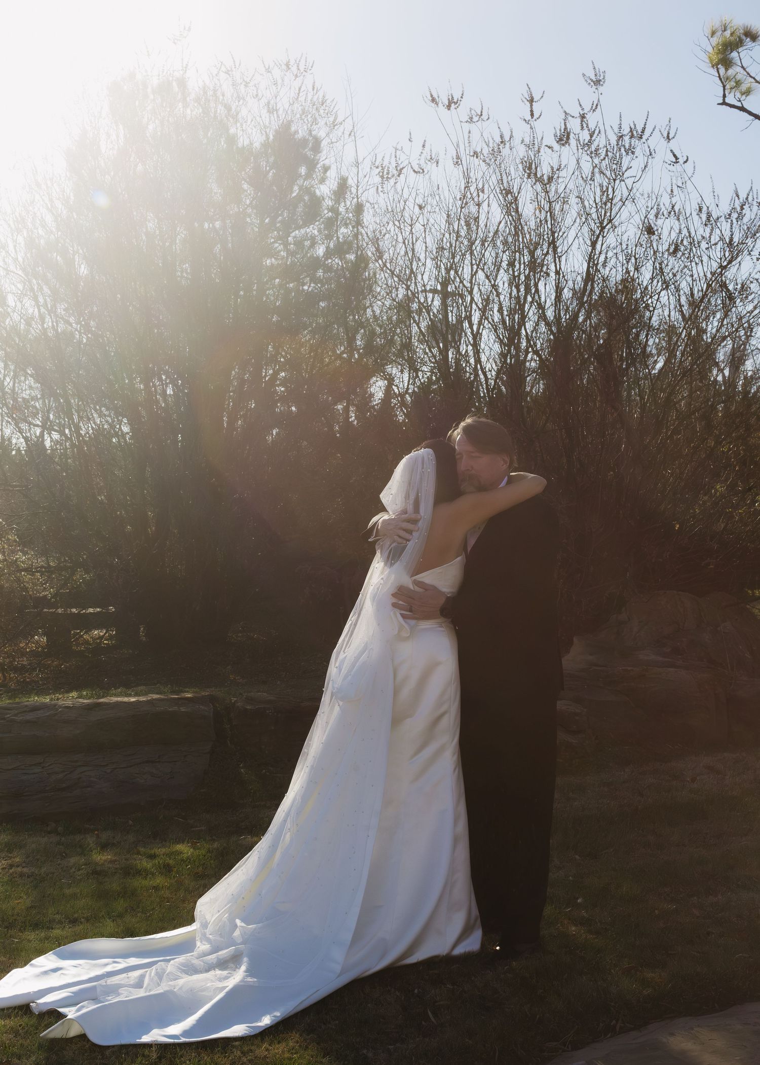 A romantic sunset wedding photo session with a flowing white dress in silhouette.