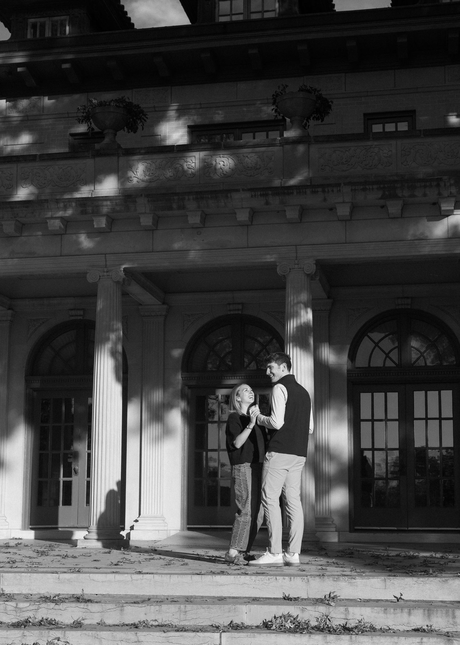 A couple in silhouette against a white columned building facade.